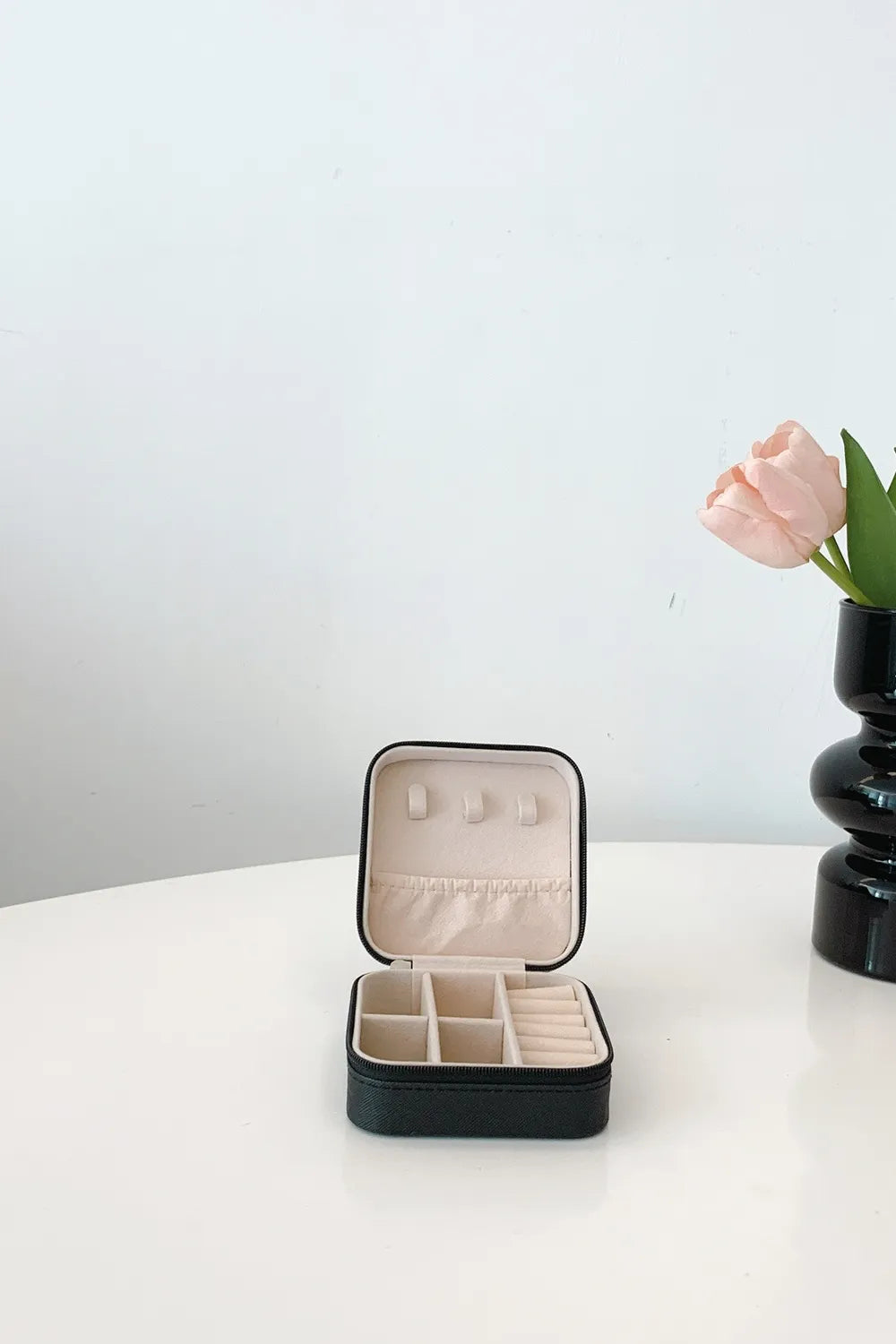 Black PU leather square jewelry box with lid open and organizer dividers inside.