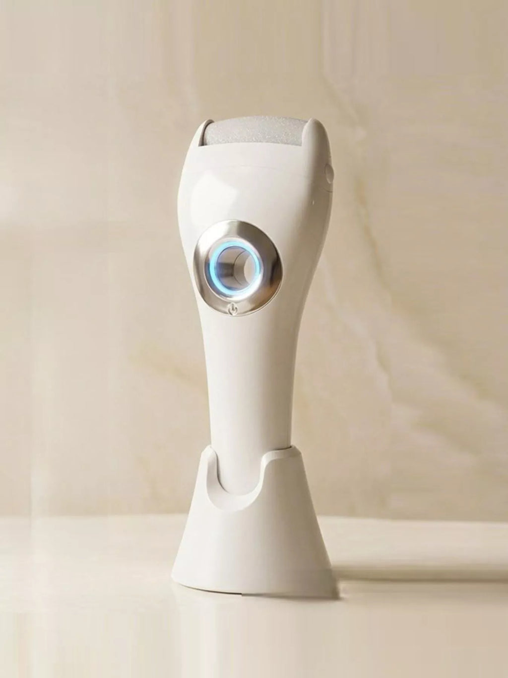 White electric foot nail buffer with blue LED ring, side view on a shelf
