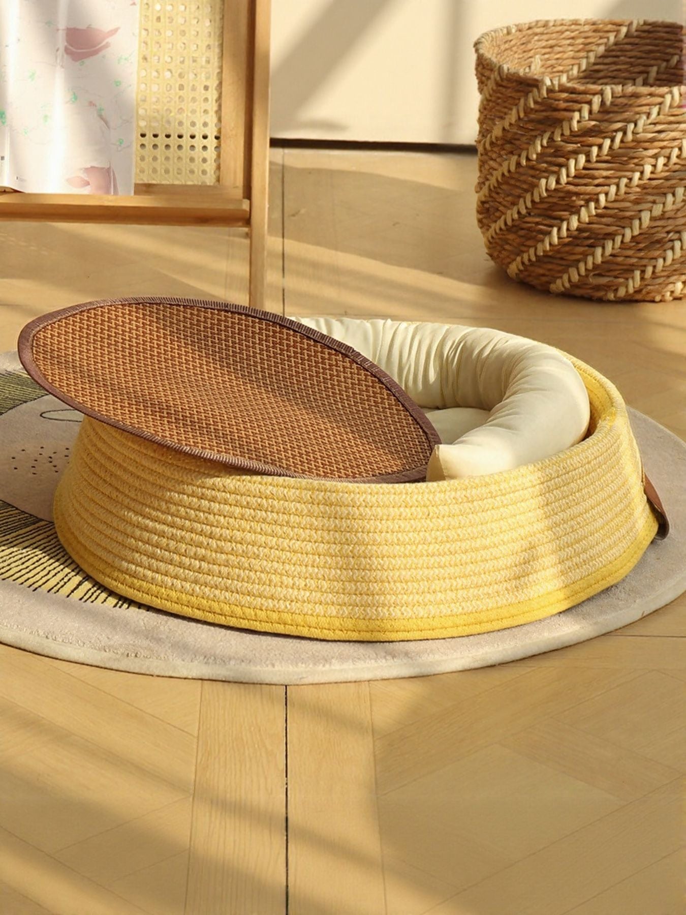 Woven rattan pet nest: open yellow round basket with beige cushion and brown inner cover