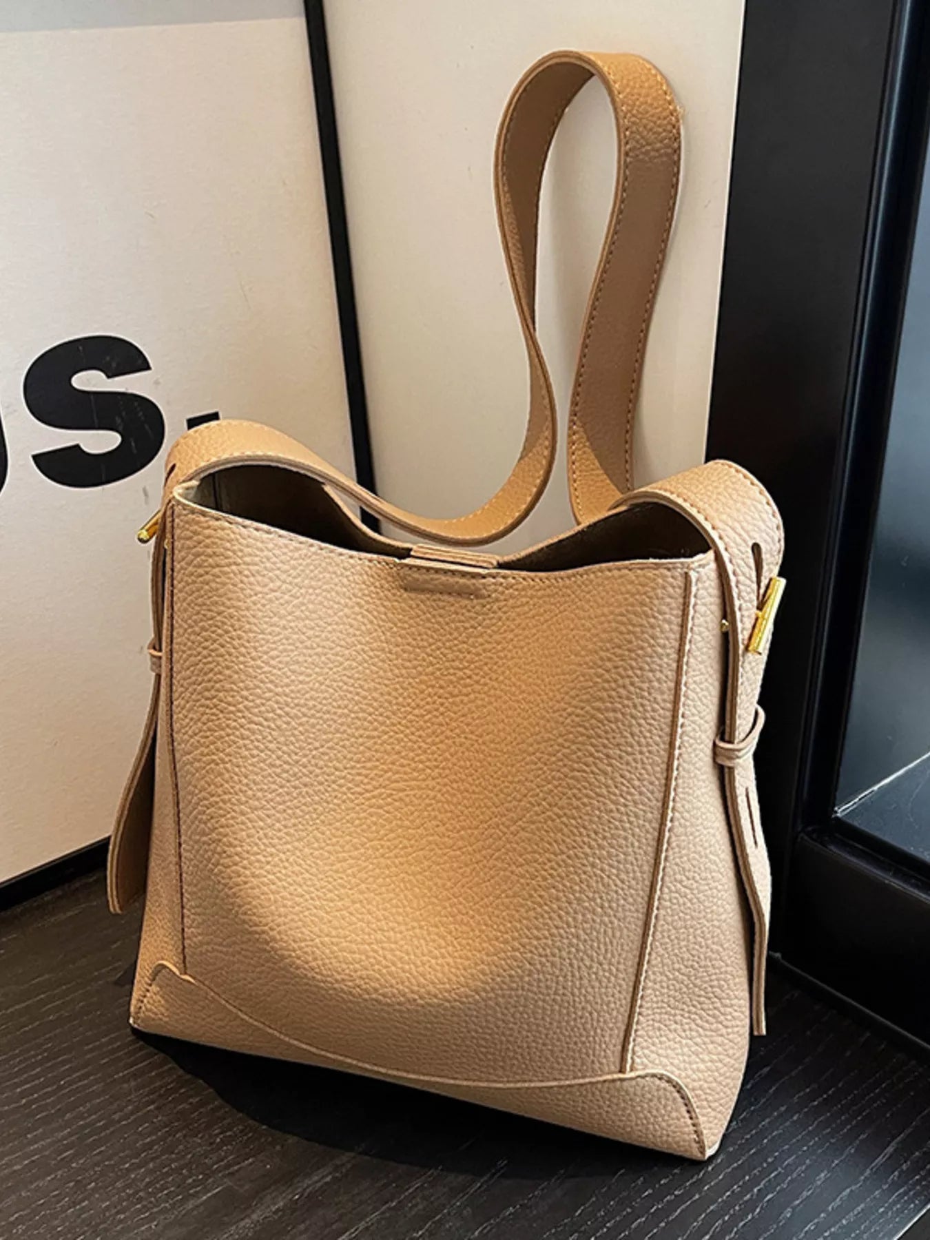 Khaki leather crossbody bag angled view with adjustable strap and zip-top