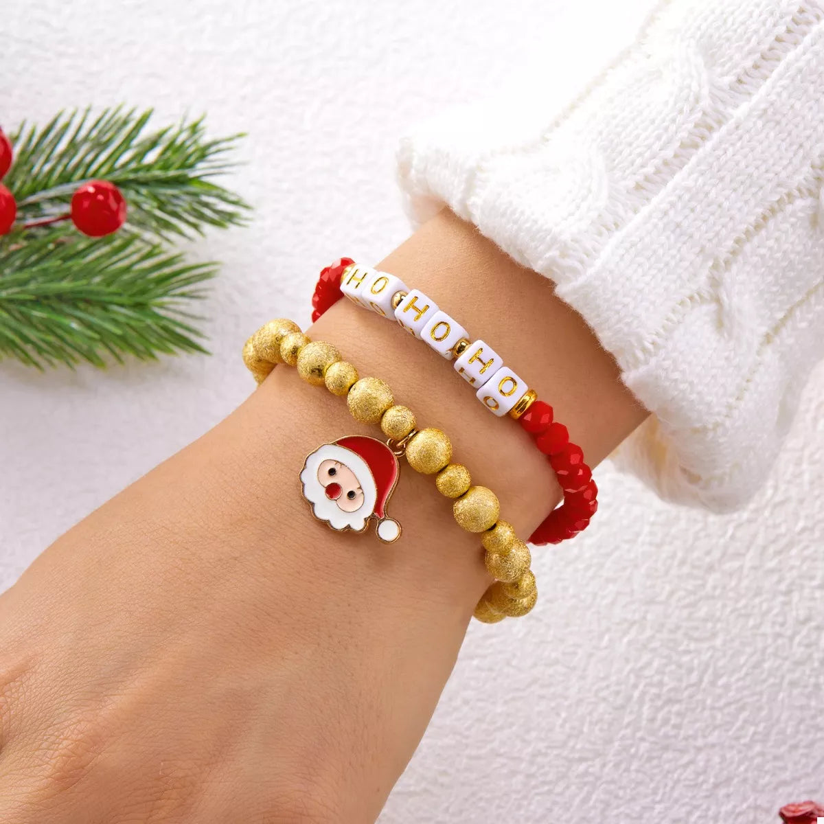 Red and gold beaded bracelet with HO HO HO beads and Santa face charm on wrist