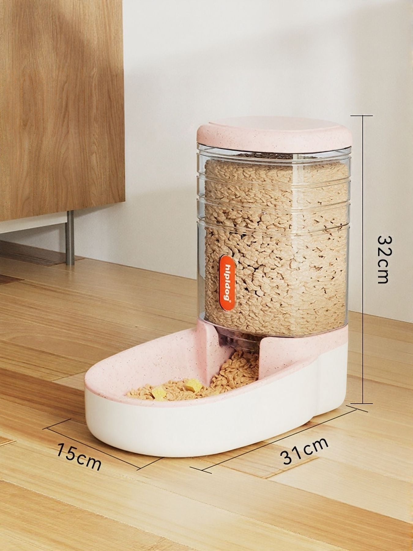 Pastel pink automatic pet food dispenser with clear container filled with kibble