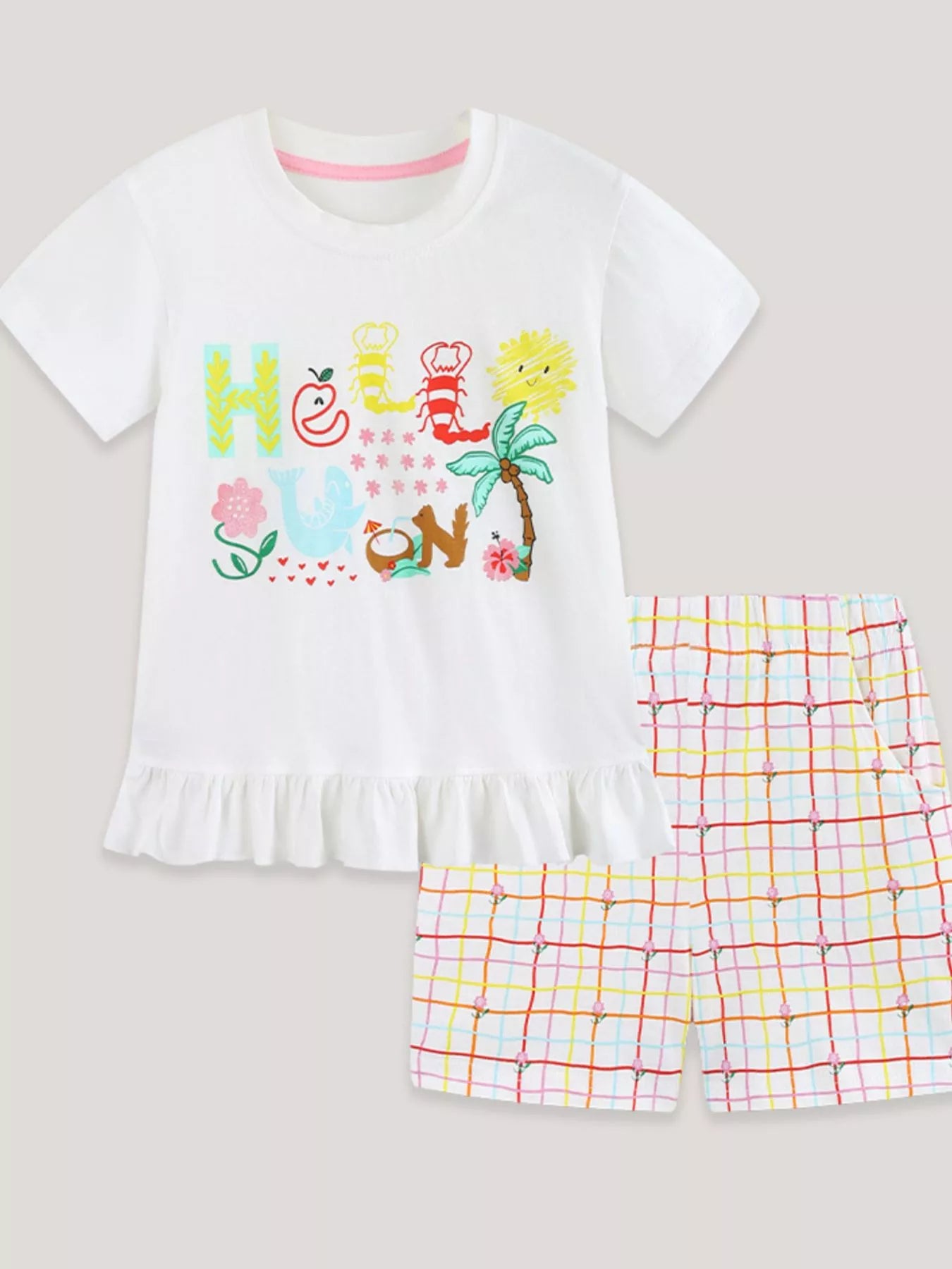 White graphic T-shirt with ruffle hem and multicolor plaid shorts set, flat lay