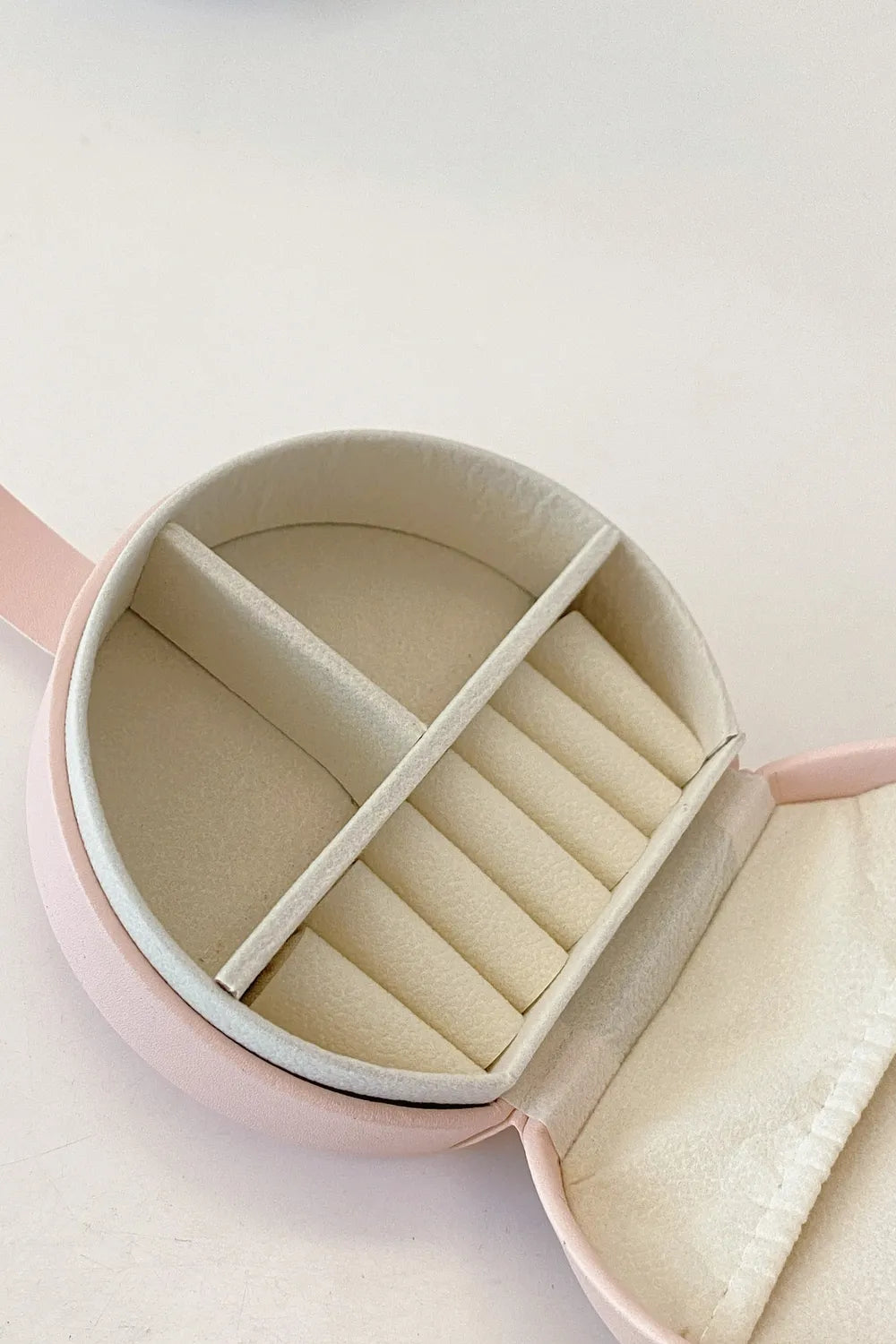 Blush pink PU leather travel jewelry box interior with padded necklace and earring slots