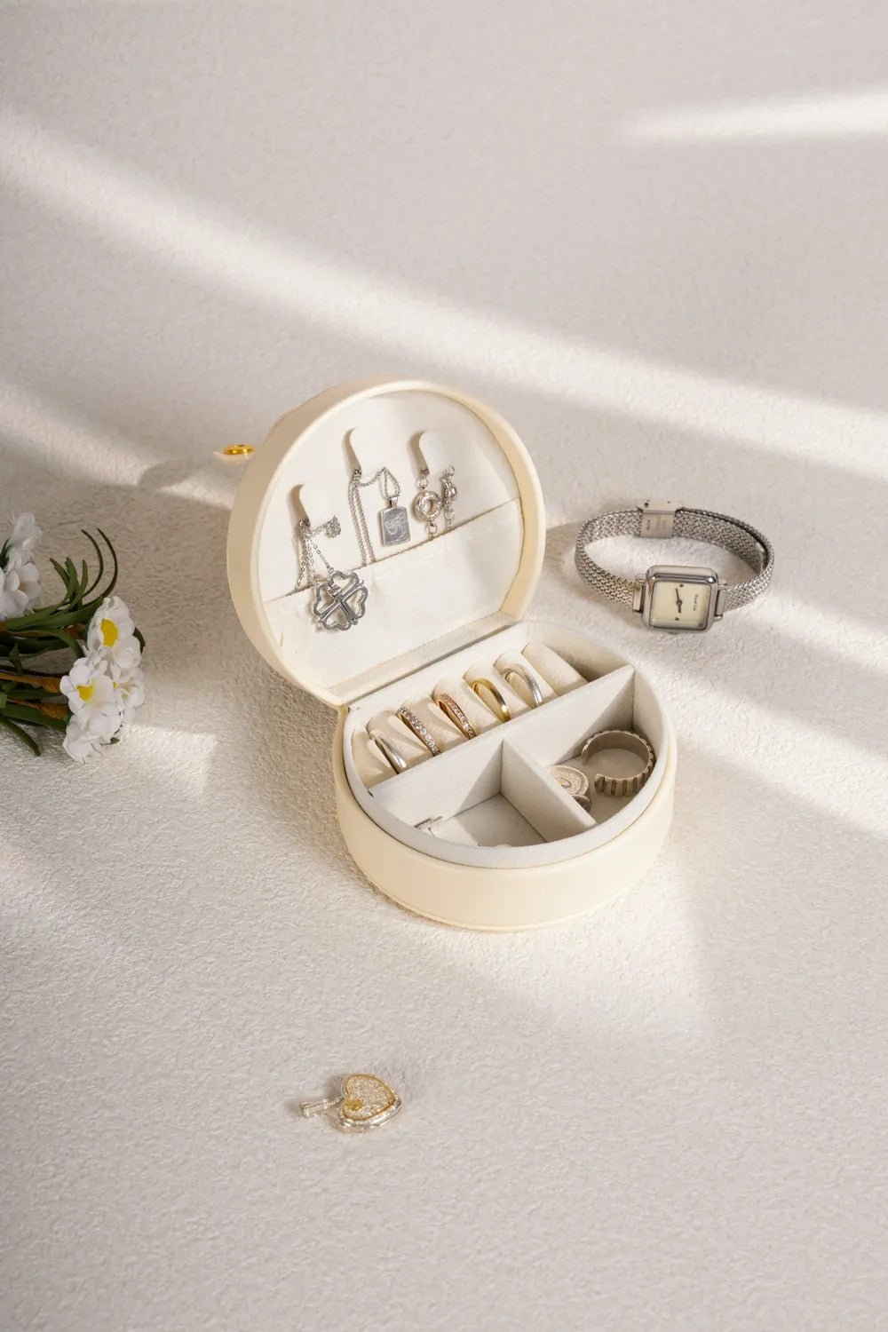 Cream PU leather travel jewelry box with open lid, earring hooks, and watch holder
