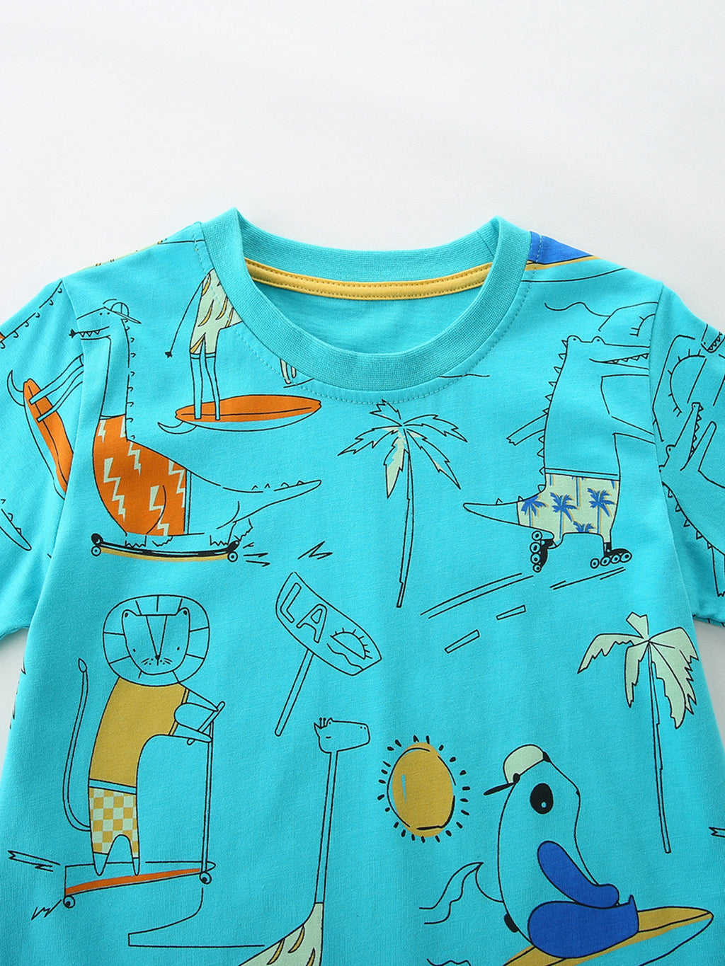 Close-up aqua T-shirt with cartoon animal, surfboard and palm tree print