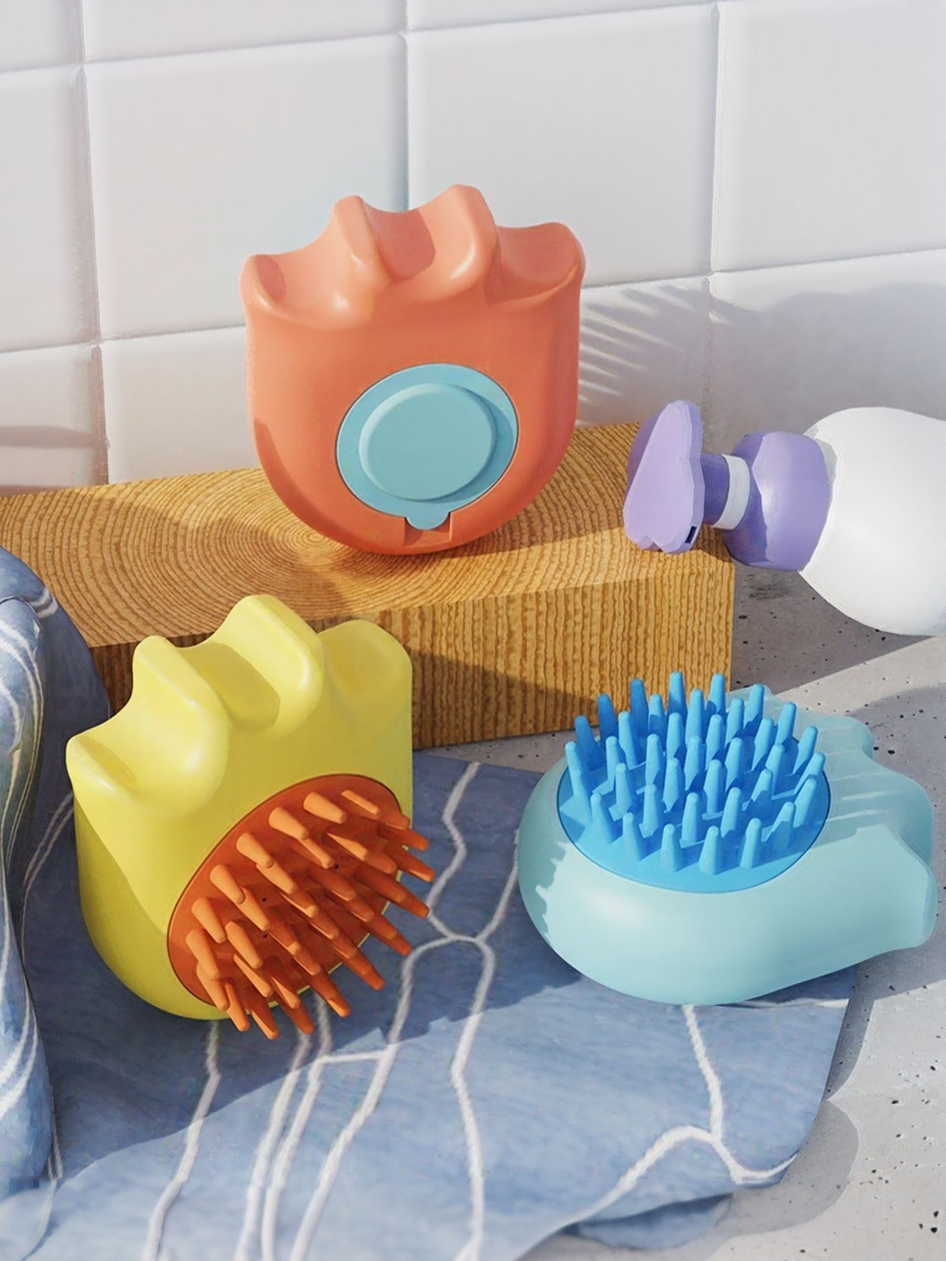 Three pet shower brushes: orange, yellow, and blue, with ridged scrub bristle tops