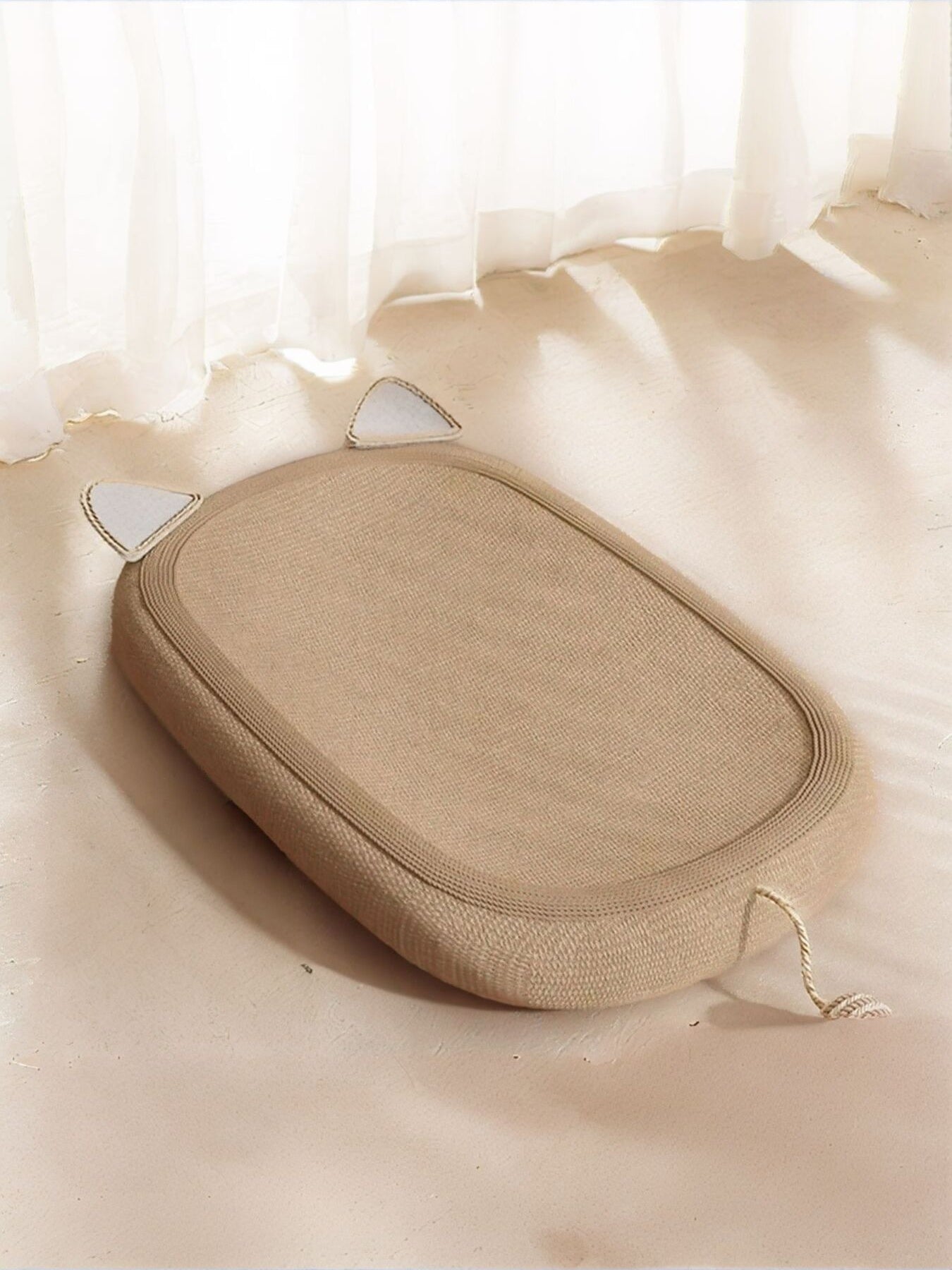 Oval tan cat scratching bed with rope trim and triangular openings
