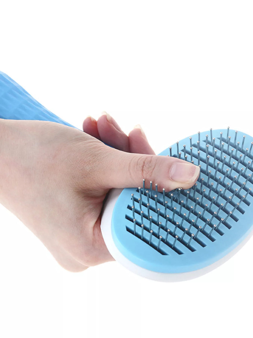 Sky blue pet hair remover comb in hand brushing with dense metal pin teeth