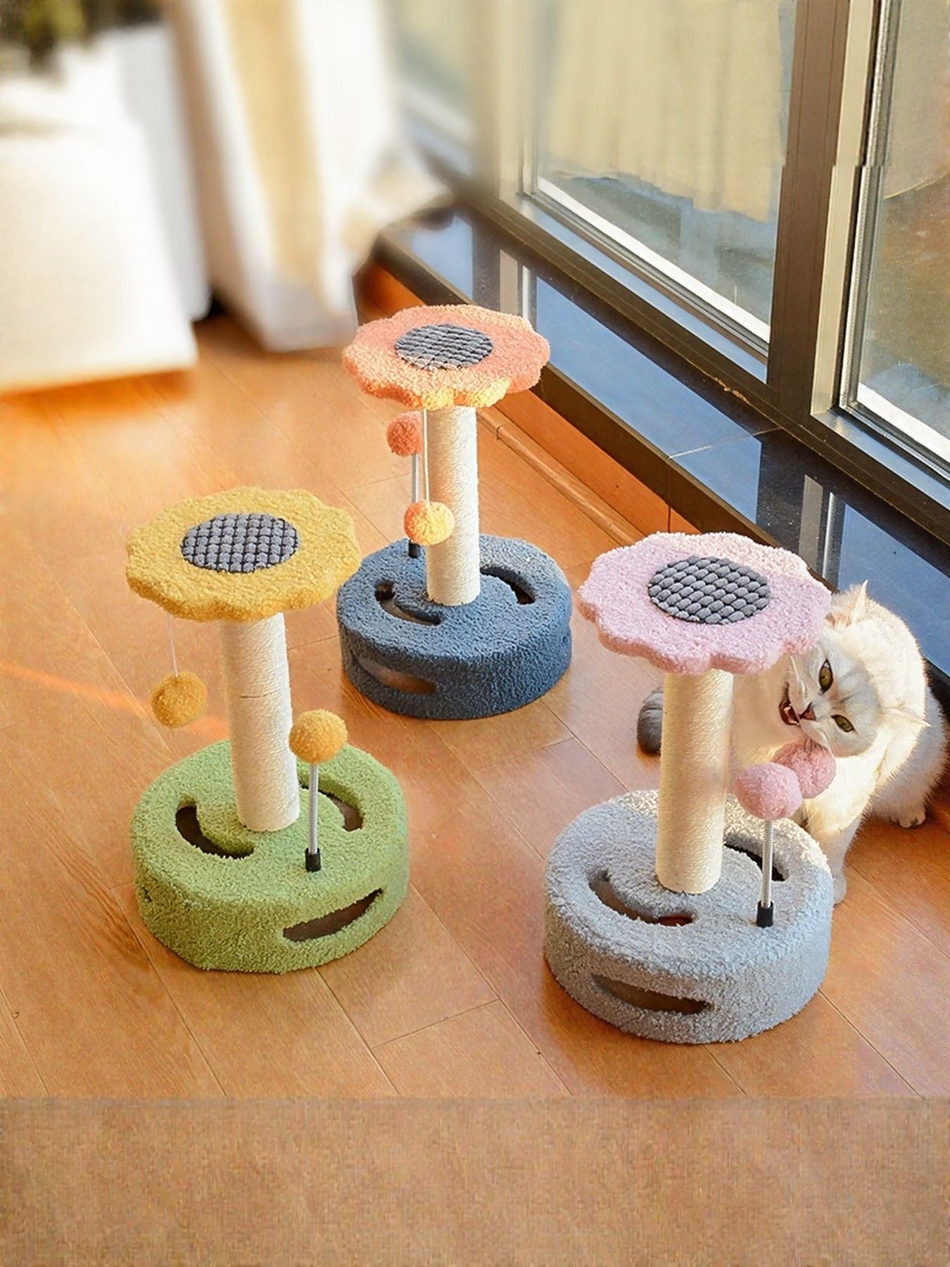Cat scratching post with dangling balls—yellow, orange, green, and blue circular tops