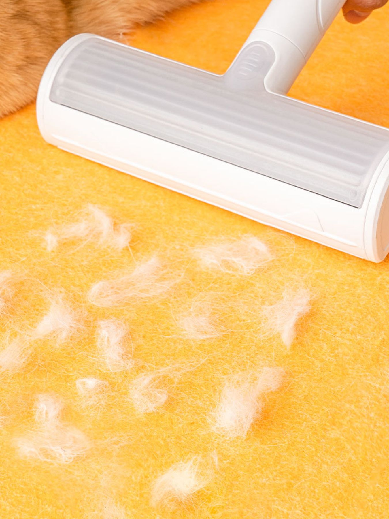 White lint remover tool smoothing yellow felt surface on the cat house tunnel