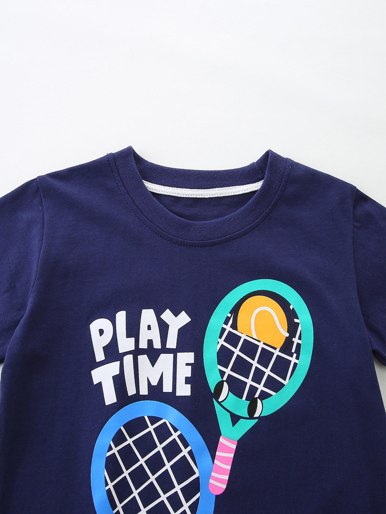 Dark navy crew-neck T-shirt close-up: 'PLAY TIME' text and tennis racket graphic