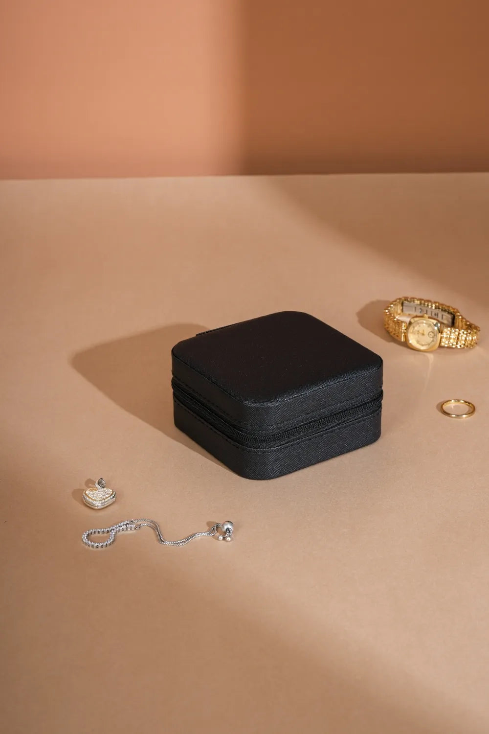 Black PU leather square jewelry box with lid closed, compact travel-size design.