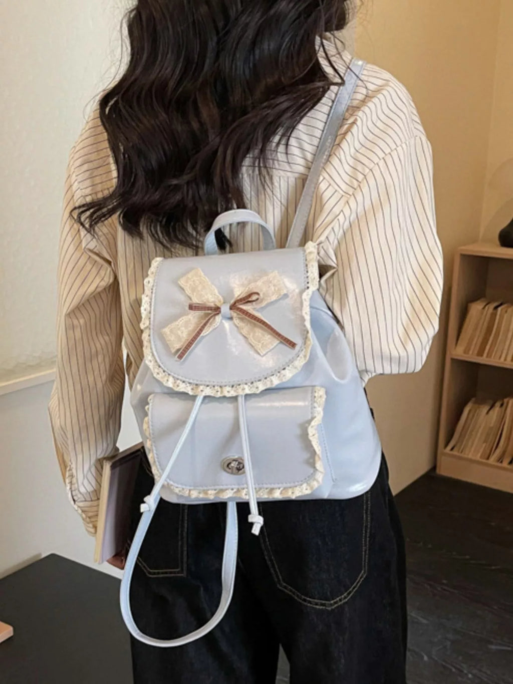 Light blue lace-trim backpack with bowknot front and hanging drawstring cords