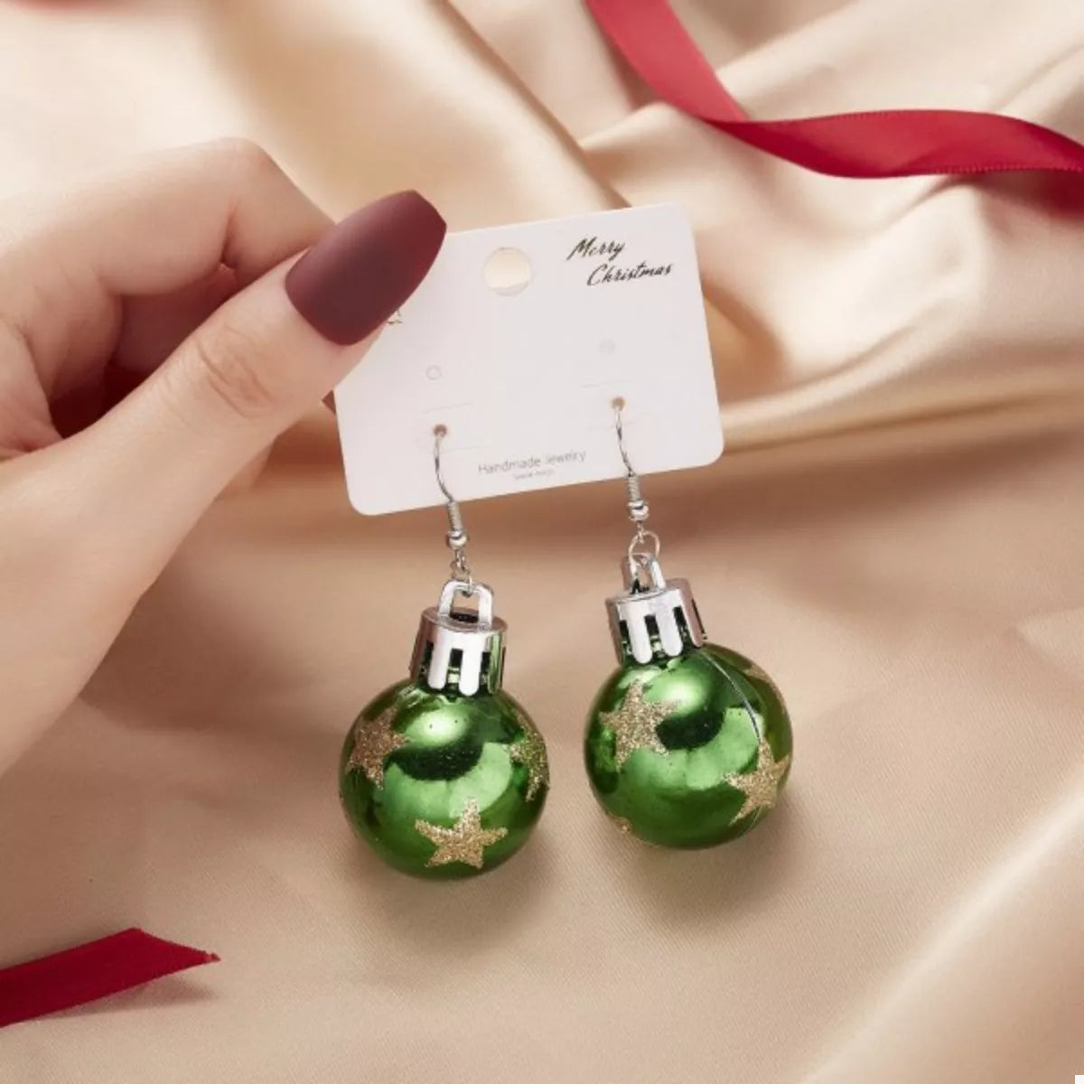 Dark green Christmas ball drop earrings with star accents and silver-tone caps