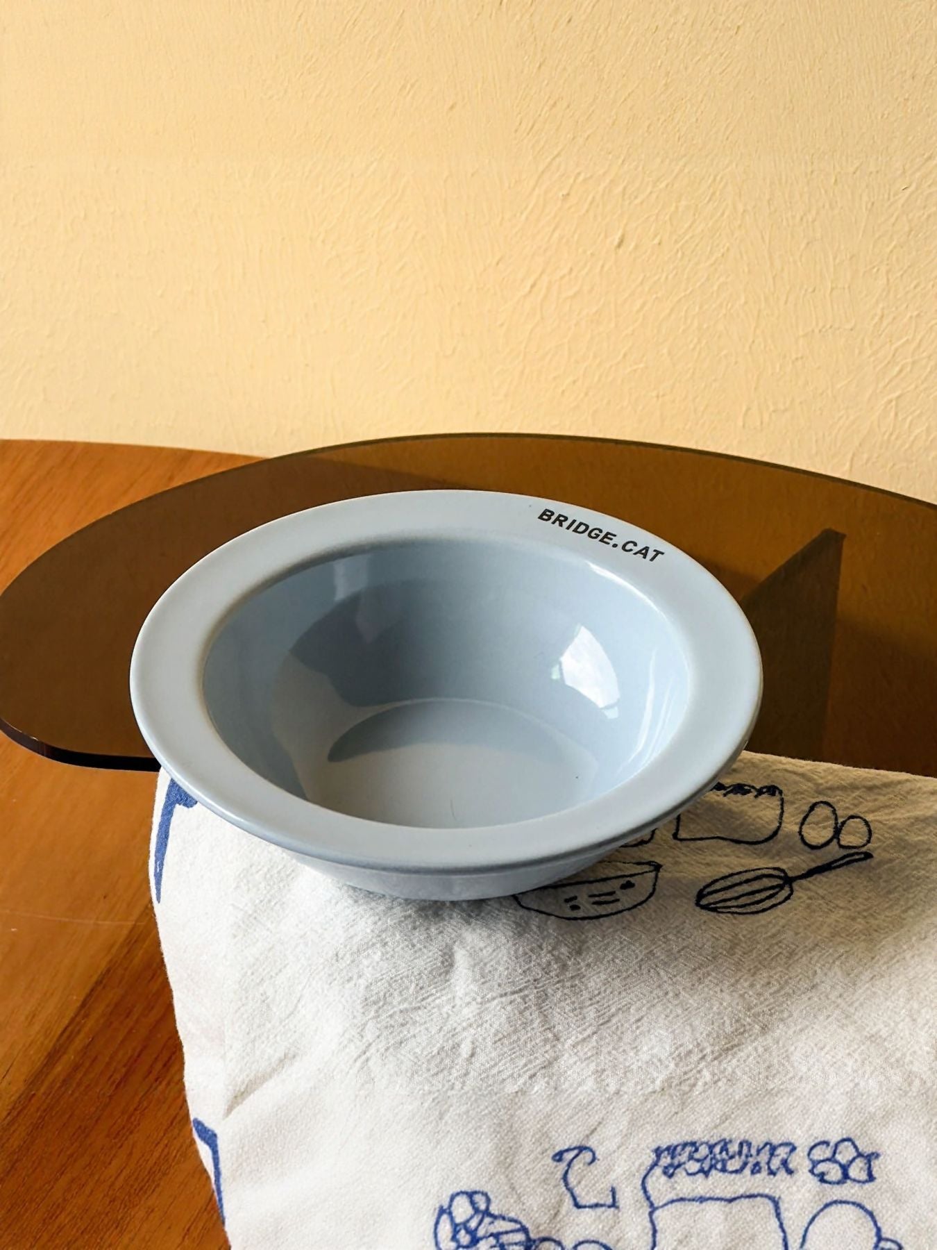 Light gray pet bowl with “BRIDGE·CAT” text on the rim
