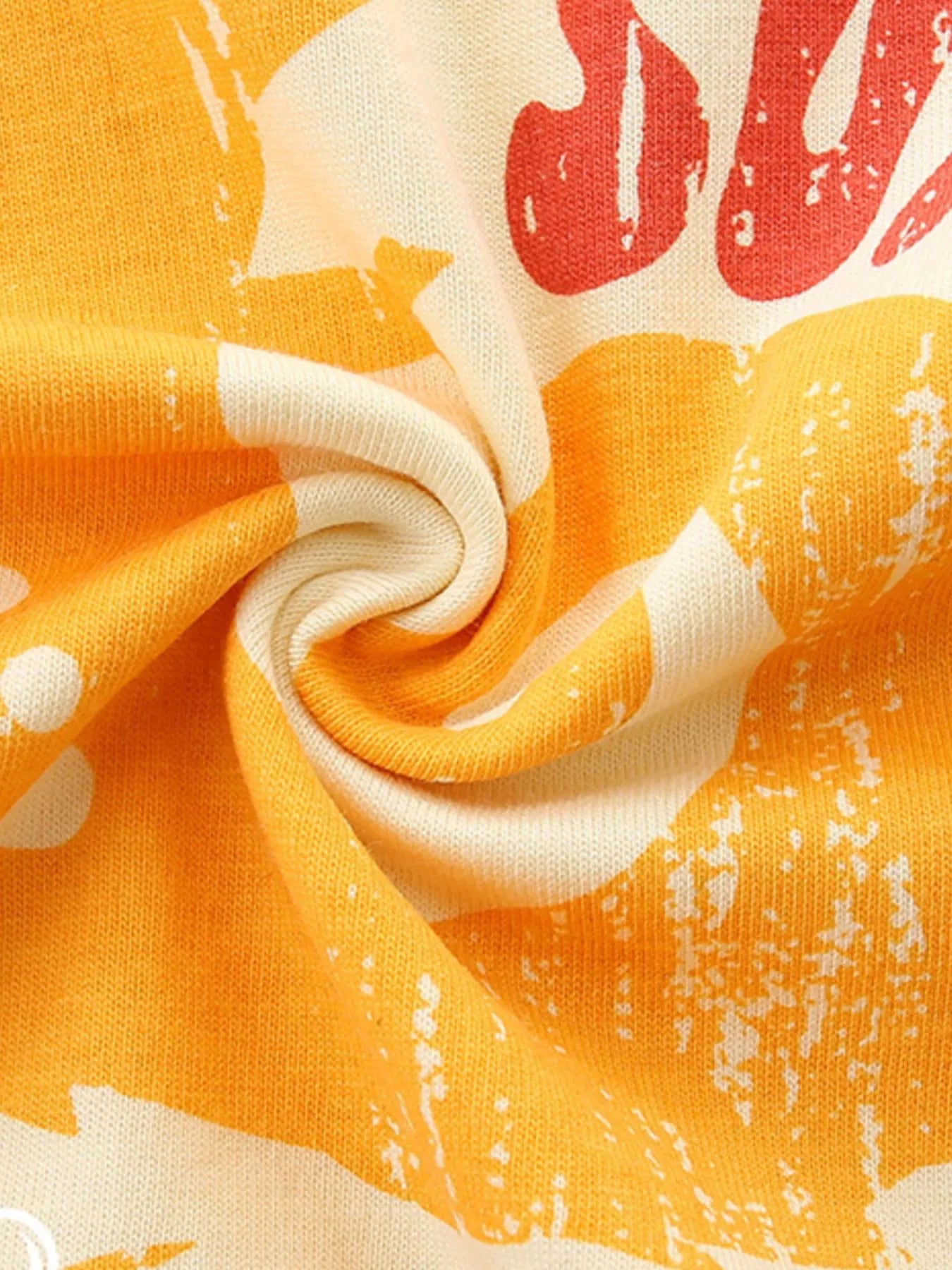 Pastel Yellow knit fabric close-up with orange and red graphic print