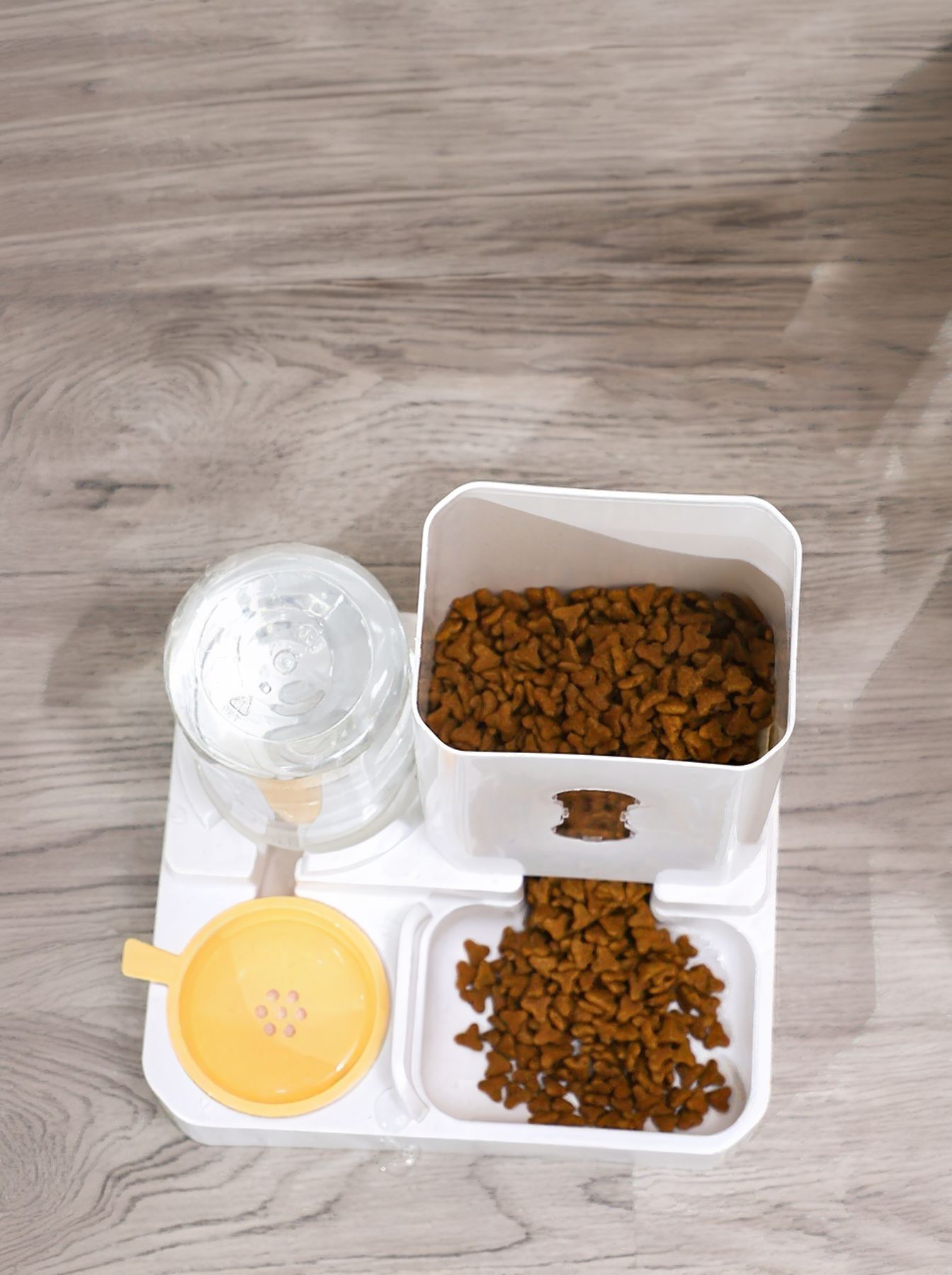 Automatic pet food and water dispenser showing filled food bins and water reservoir.