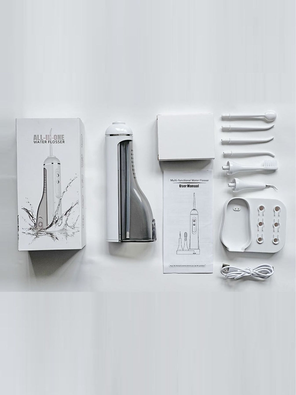 Water flosser set with white device, base, manuals, and multiple nozzle attachments