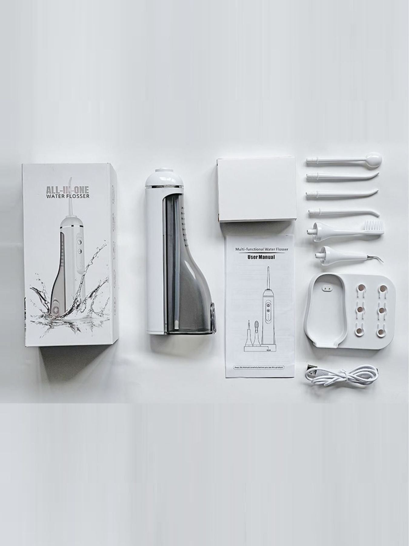 Water flosser set with white device, base, manuals, and multiple nozzle attachments