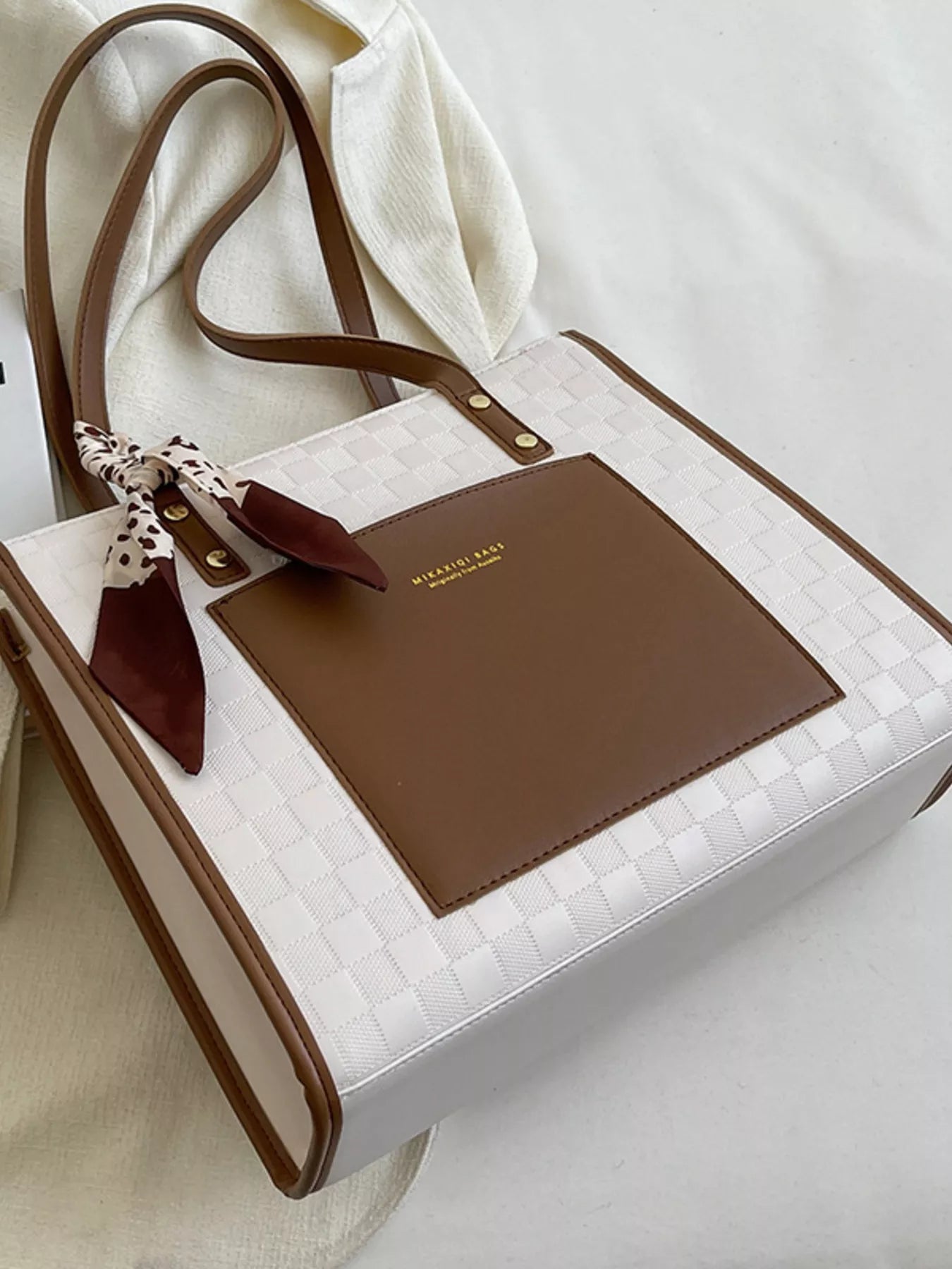 White quilted tote with brown front pocket panel, scarf bow and long straps