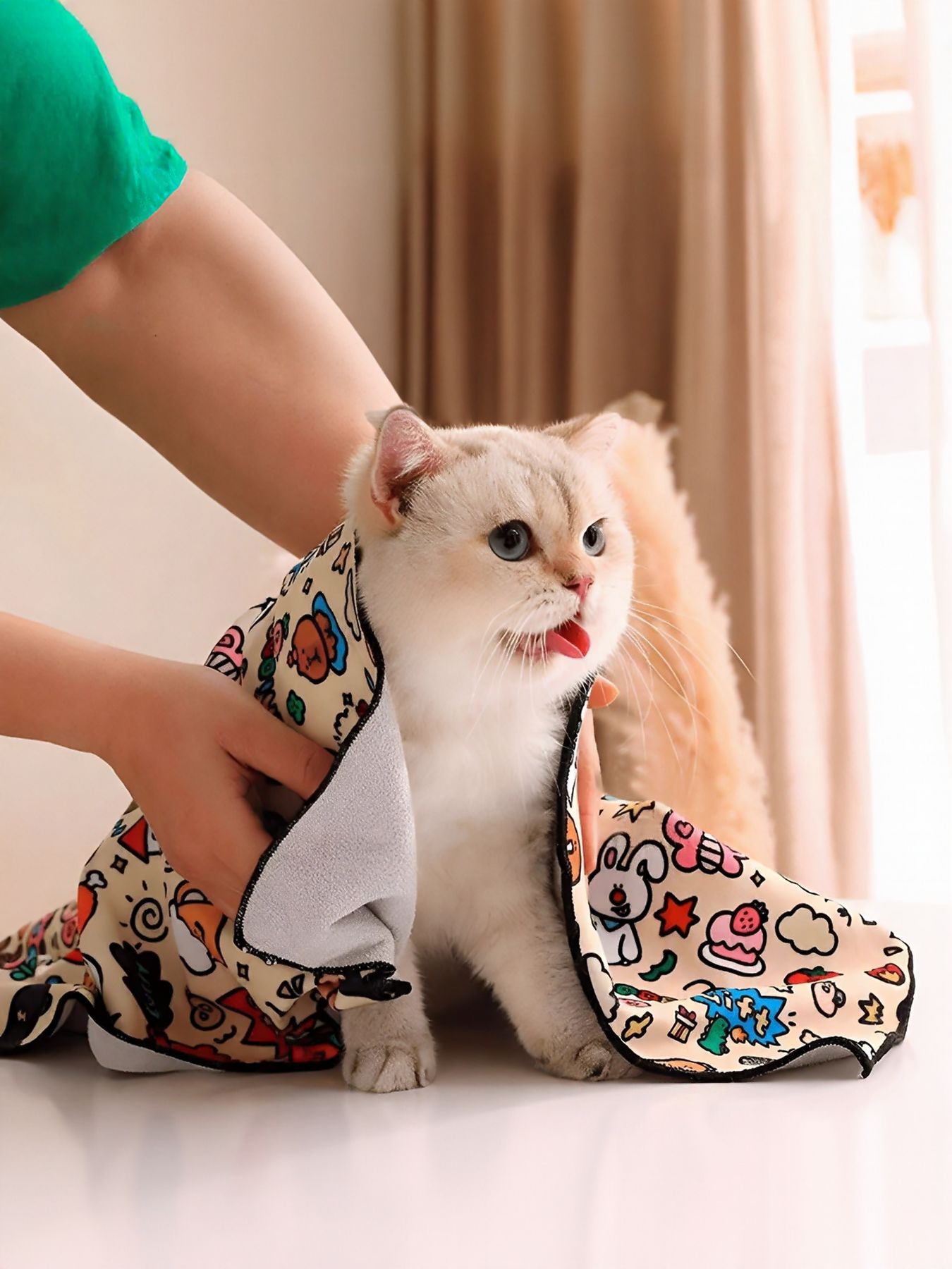 Cartoon pet bath towel with paw trim, wrapped around a small cat for drying