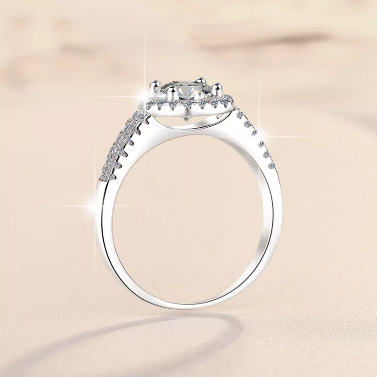 Round moissanite halo ring view from side, pavé stones along the band