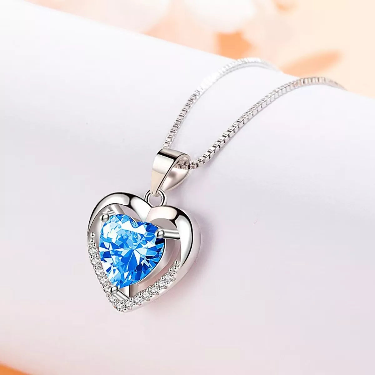 Sterling silver heart pendant with light blue zircon center and glittering pavé border