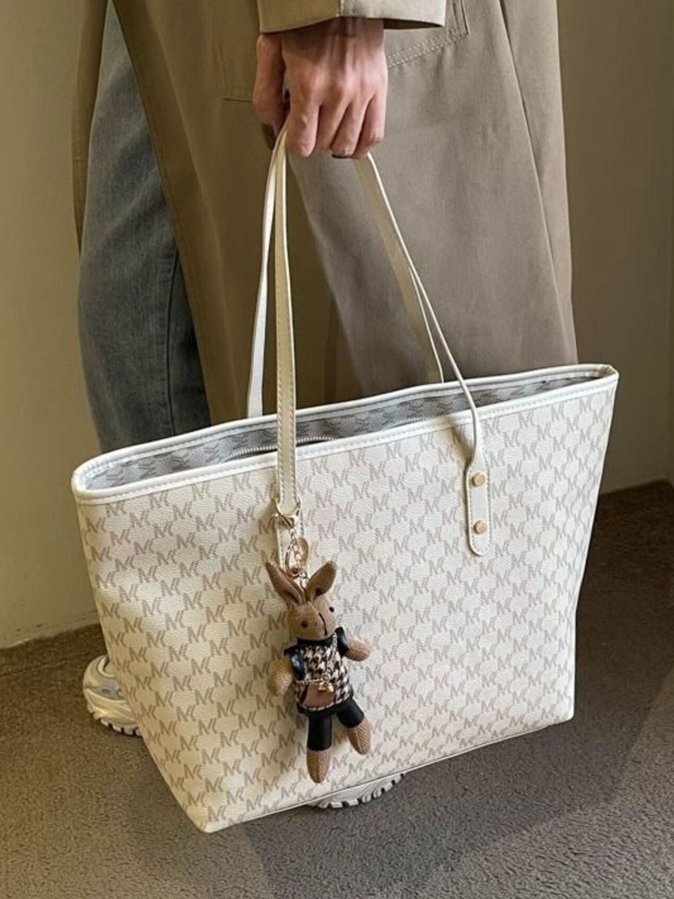 Beige tote bag with repeating monogram print, wide open top and side snap details
