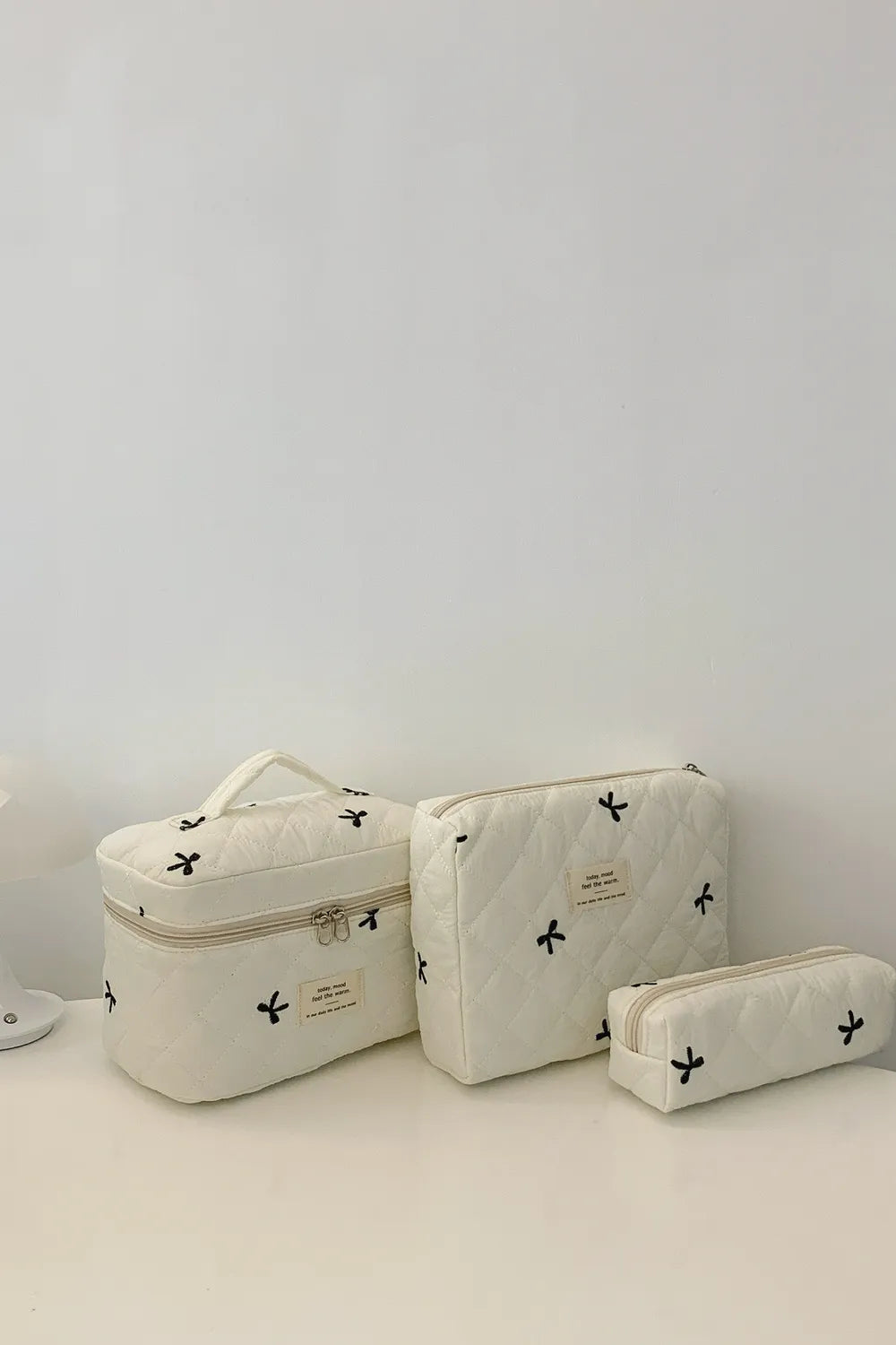 Beige quilted storage bags: two boxy zip bags and a small pencil-style pouch