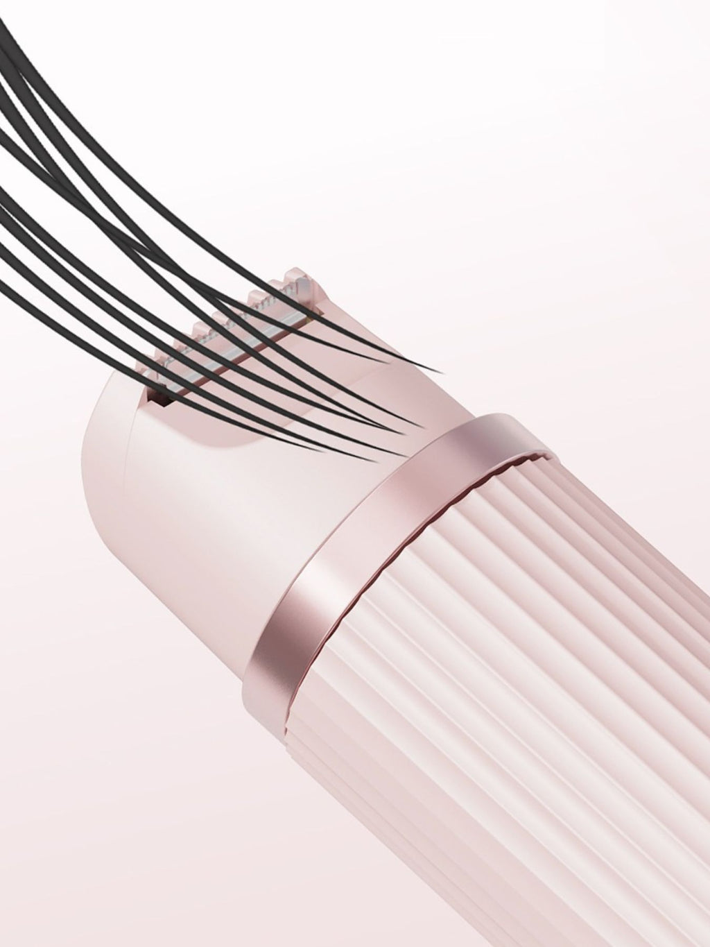 Close-up of blush pink epilator head area with textured drum rollers