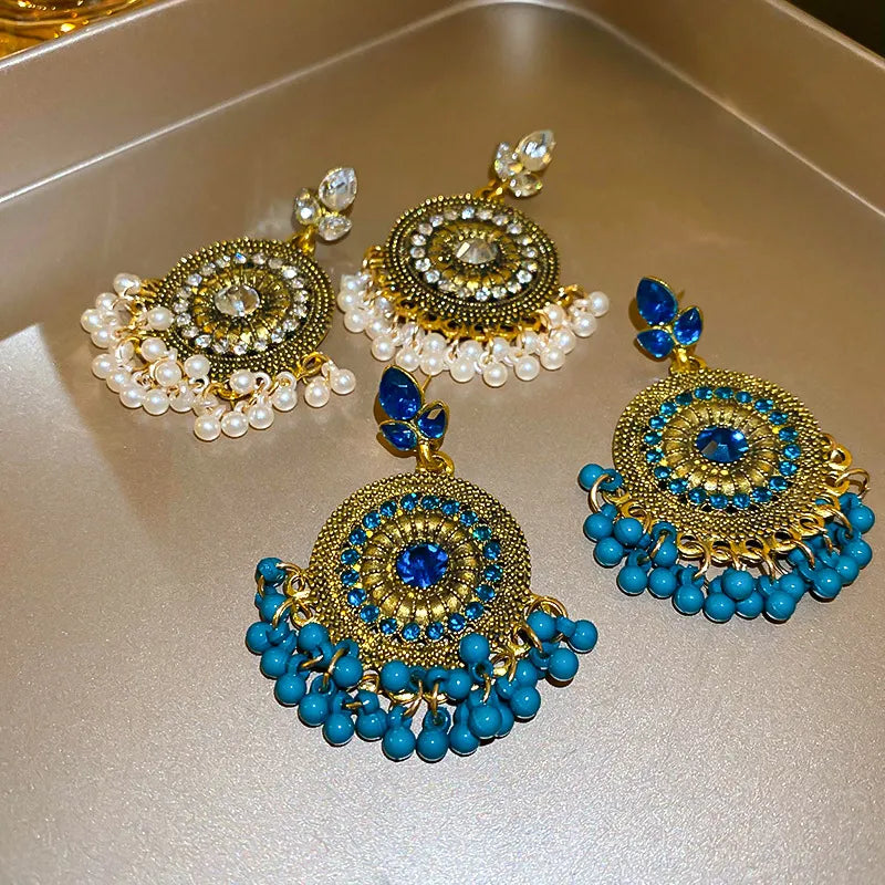 Cerulean rhinestone alloy dangle earrings with blue beaded fringe and round medallion