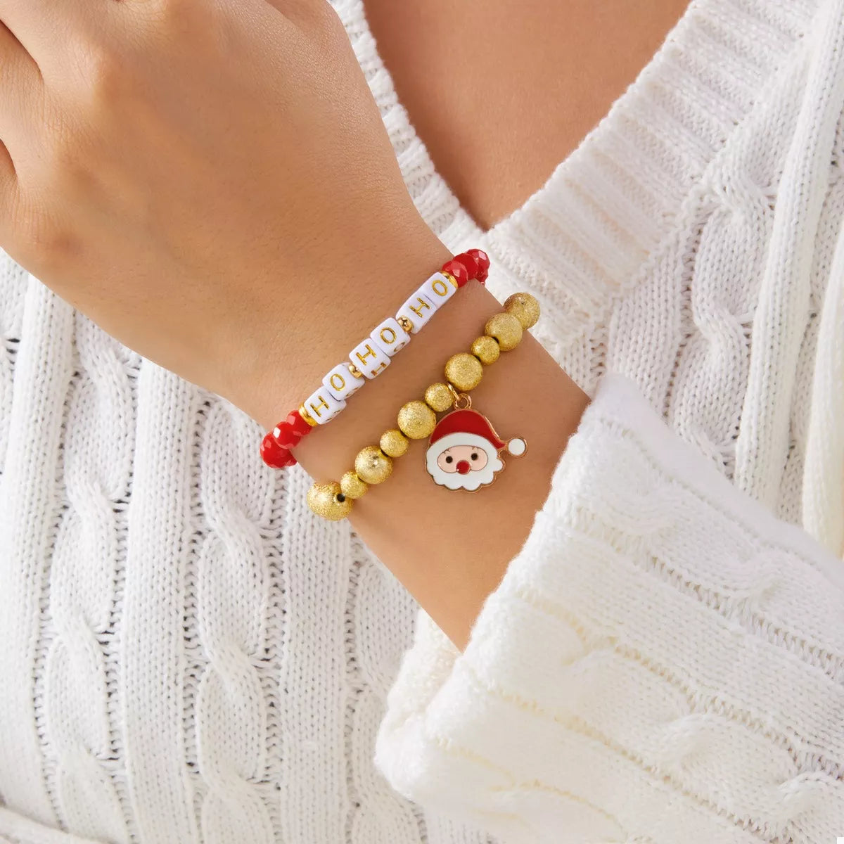 Bracelet on wrist: red and gold beads with HO HO HO text beads and Santa charm