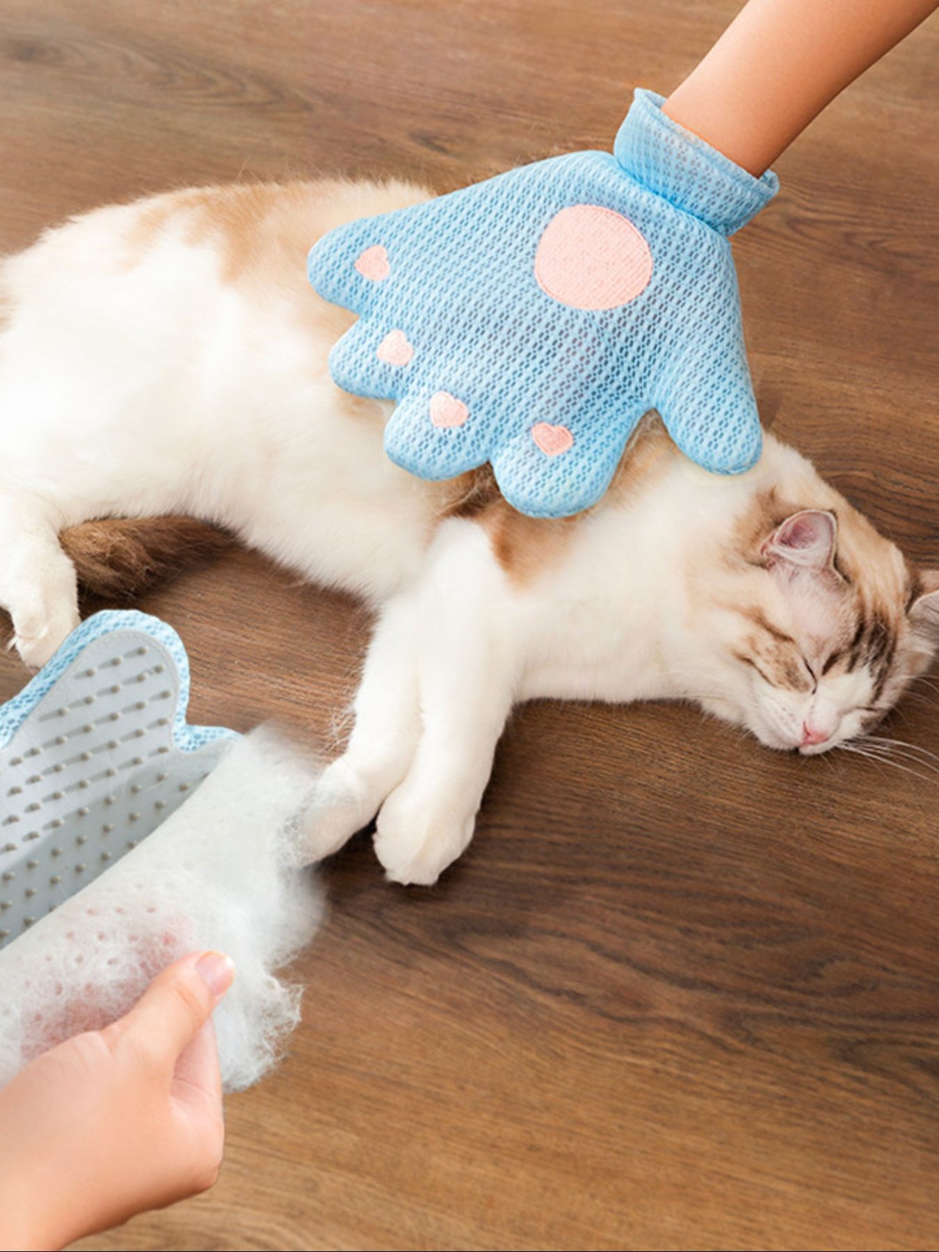 Blue pet hair remover glove in hand, paw-shaped brush for fur