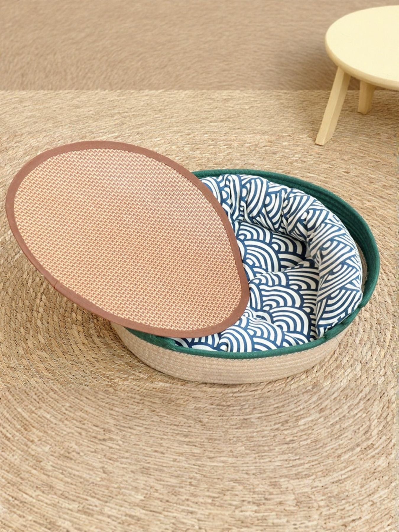 Woven Pet Nest with blue patterned cushion and green woven rim, oval basket
