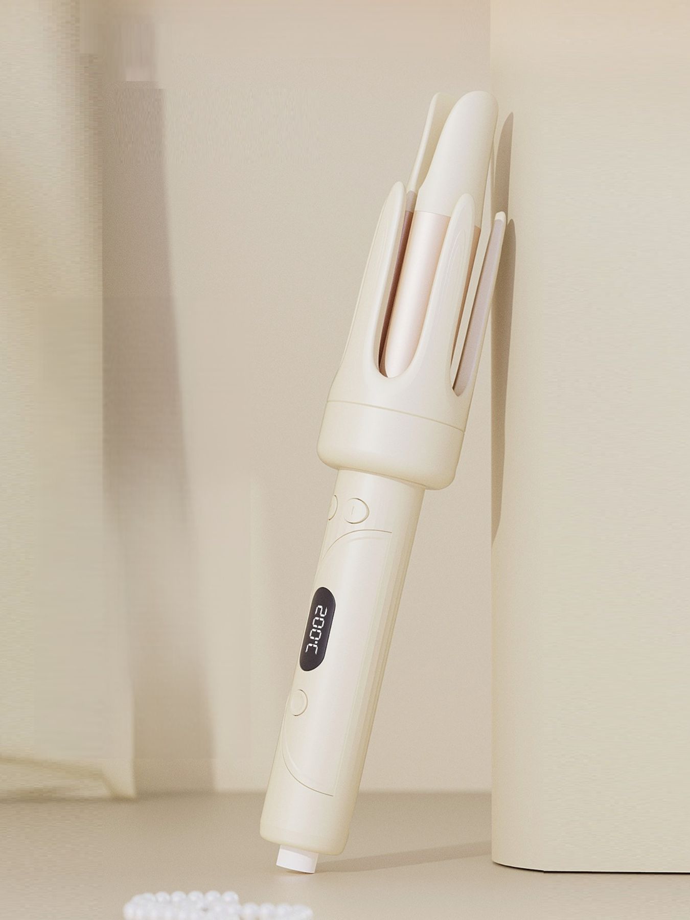 Beige automatic hair curling iron angled view showing three barrels and side controls