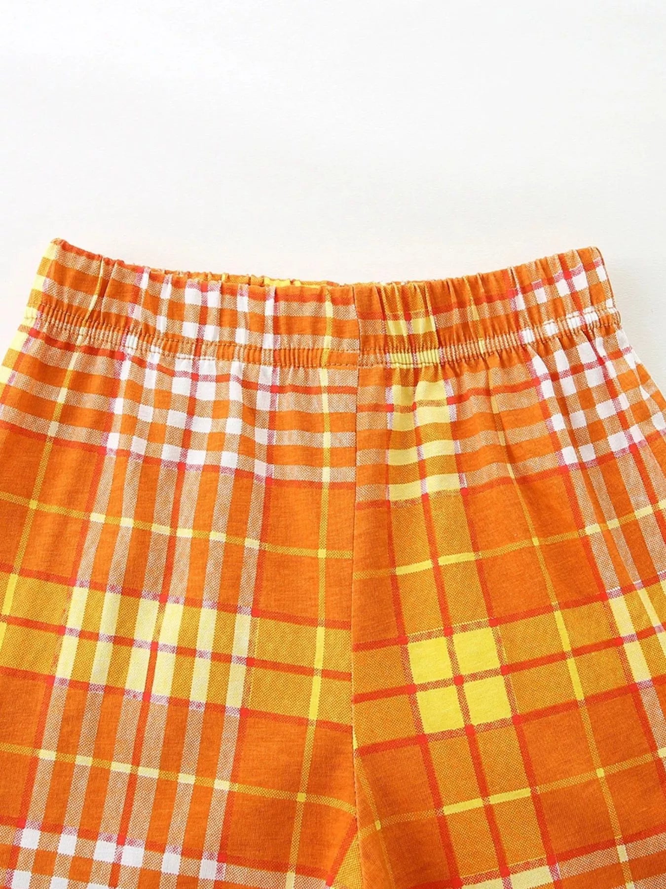 Orange plaid shorts with elastic waistband and button-style front detail