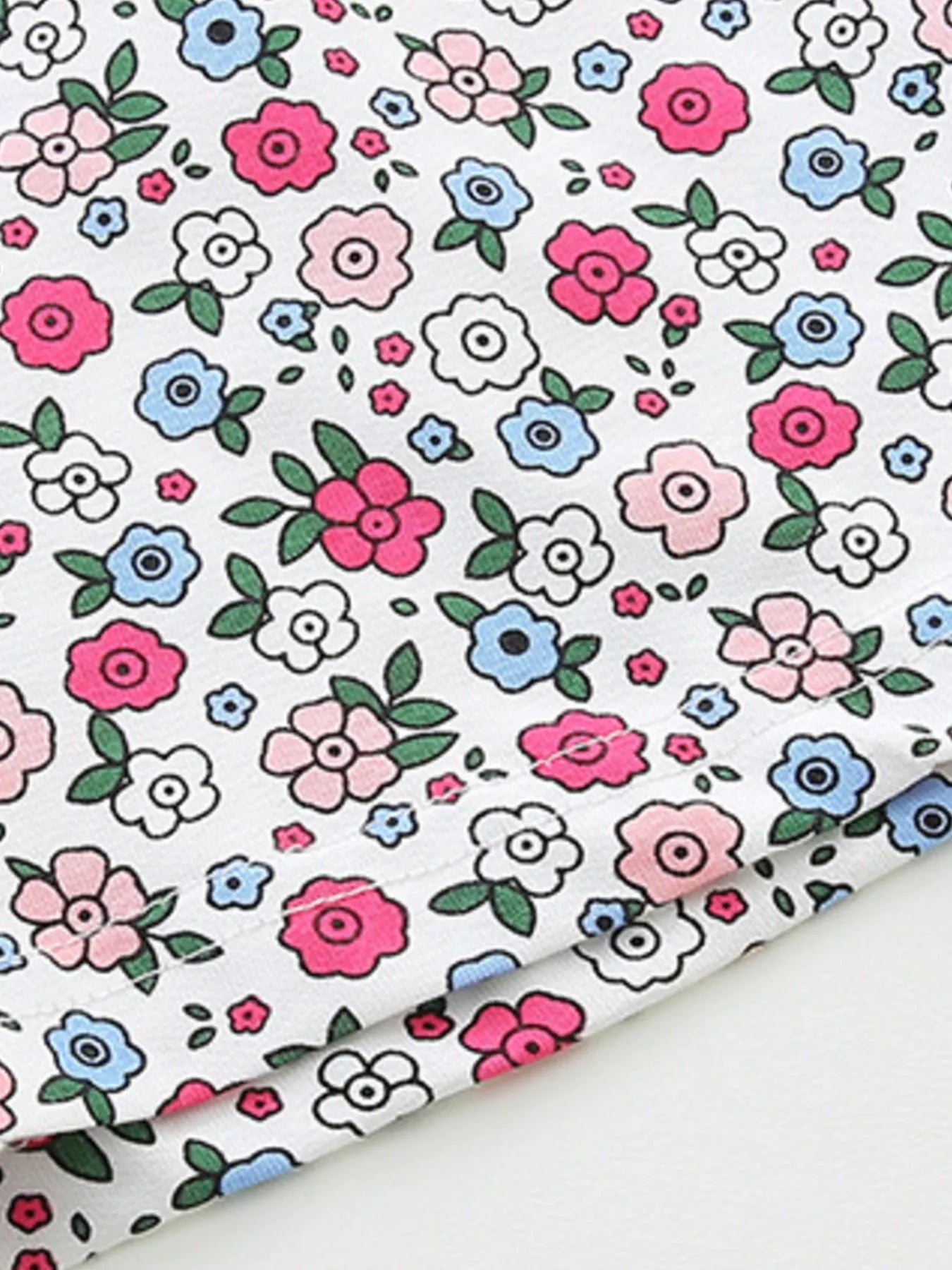 White fabric for floral shorts with colorful pink, blue, and green flower print
