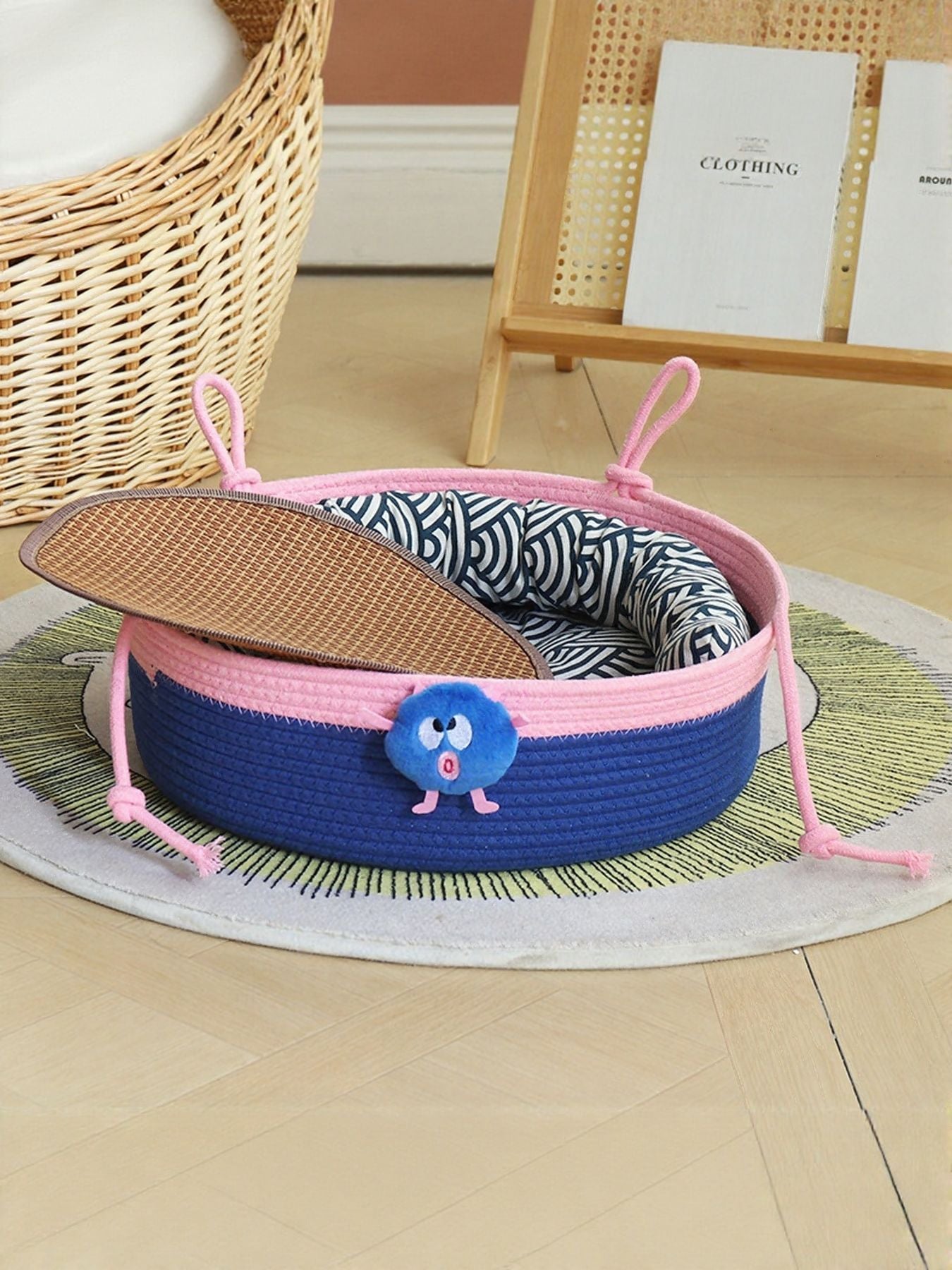 Two-tone woven pet nest with blue base, pink trim, and patterned inner liner
