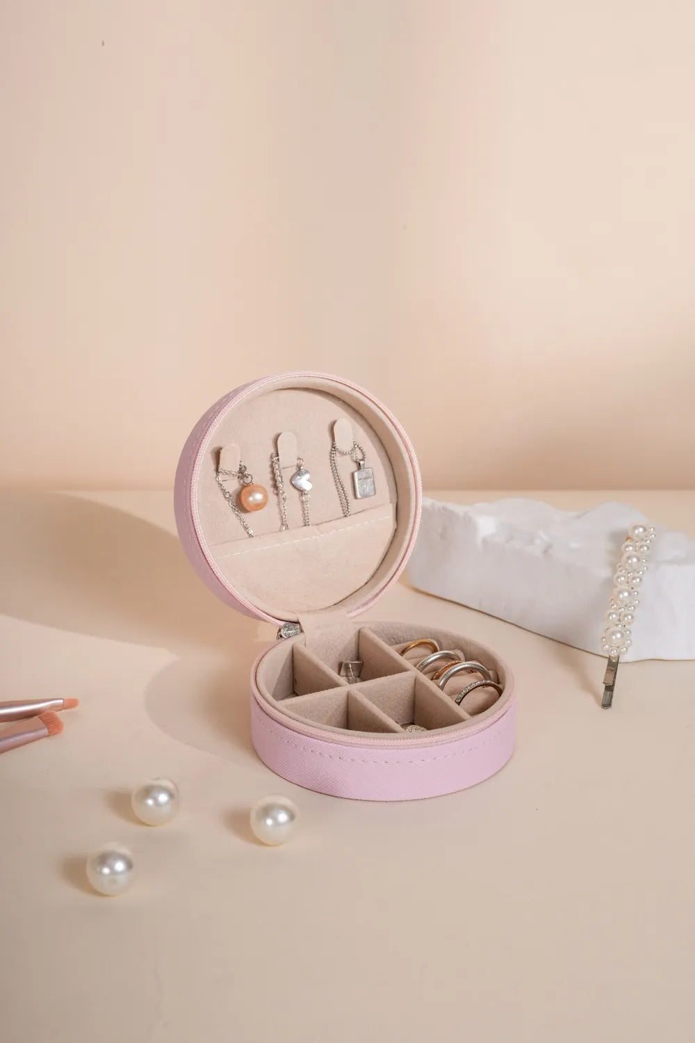 Blush pink PU leather jewelry storage box, round zipper case open with jewelry compartments