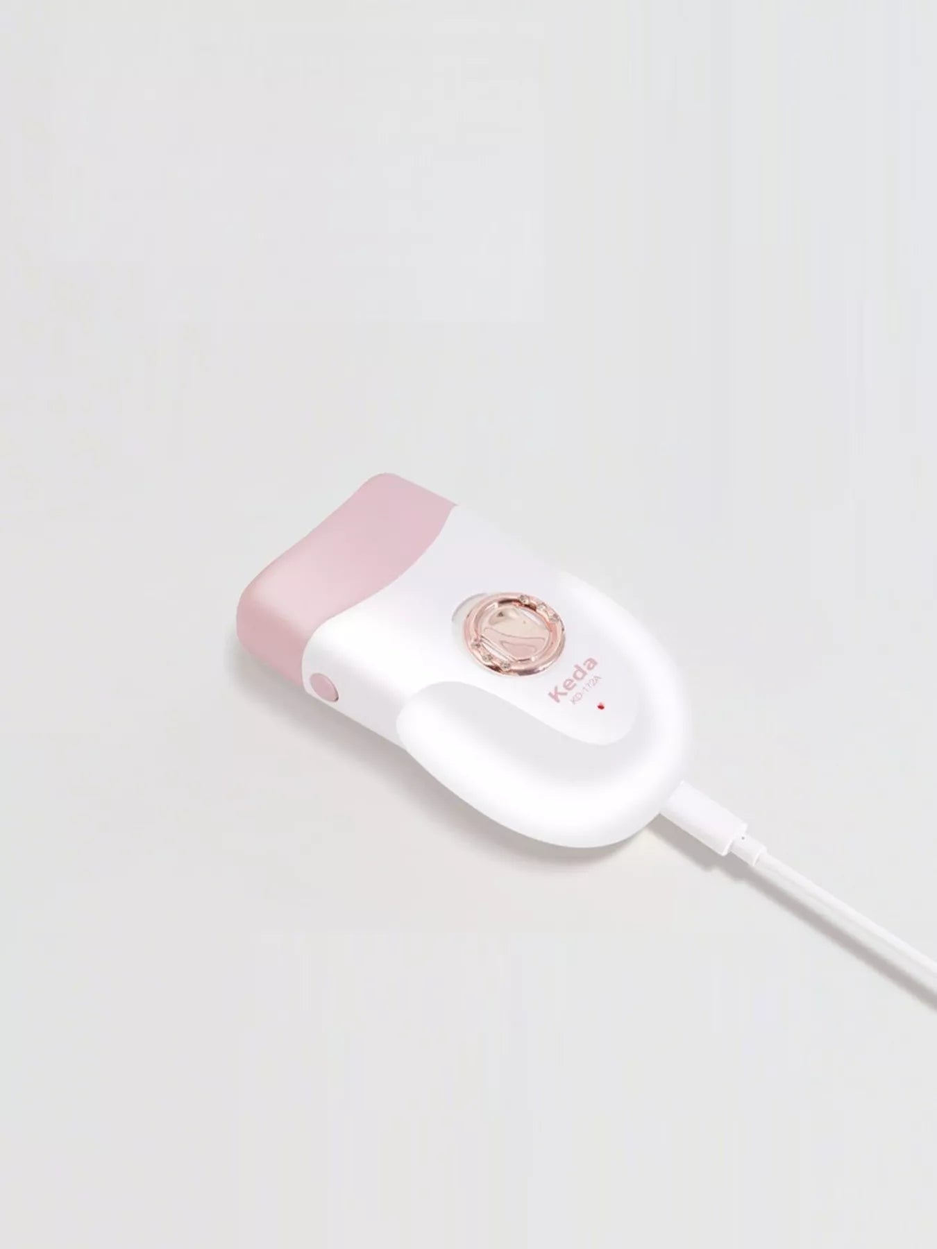 Handheld clip hair remover with white handle and pink top, rose-gold circular head