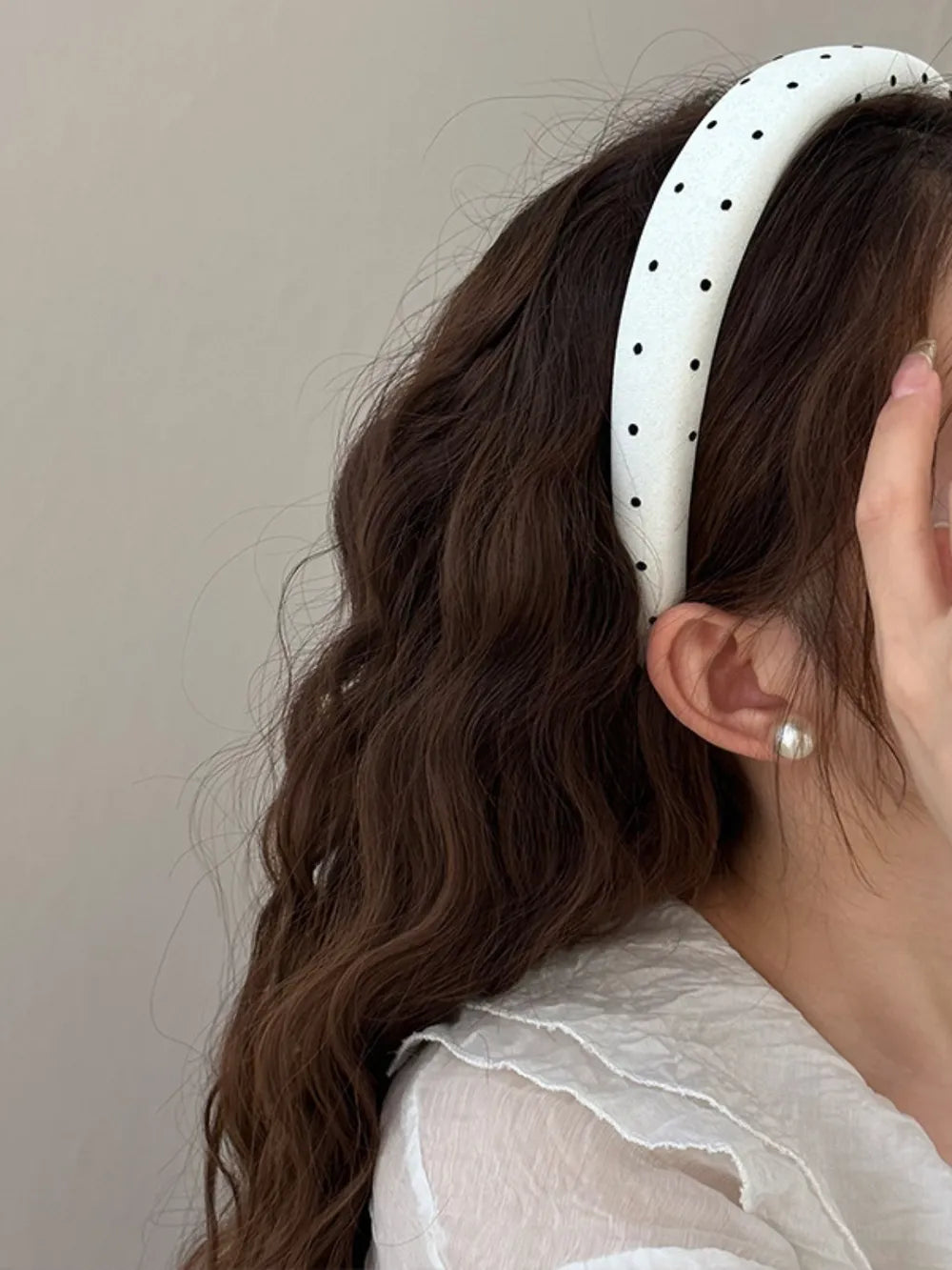 White polka dot wide headband worn on hair with black dots