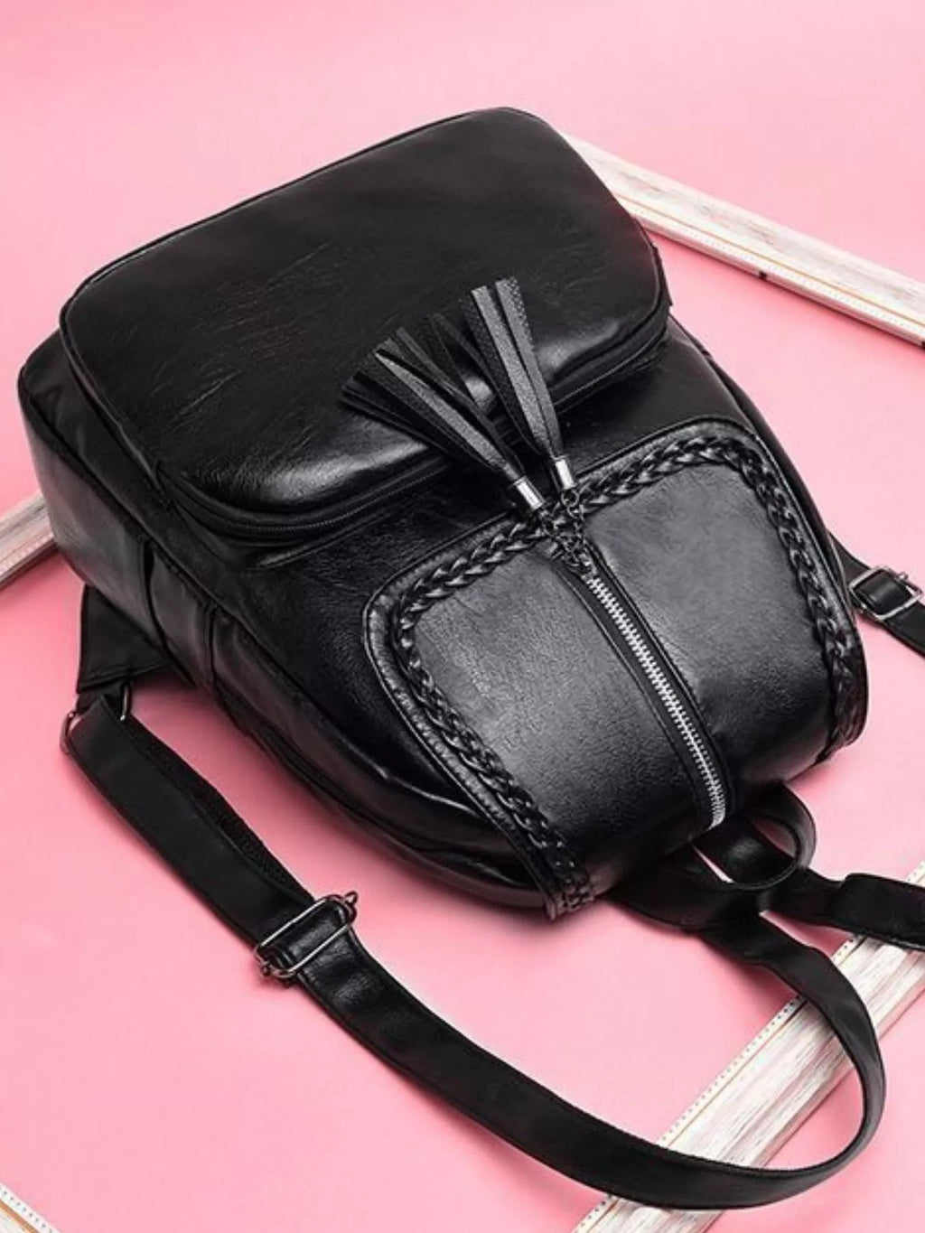 Black leather backpack bag with braided trim, front zipper and adjustable strap