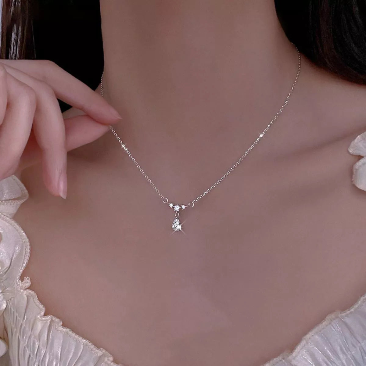 Teardrop zircon necklace worn close-up on the neck with a dangling pear-shaped pendant
