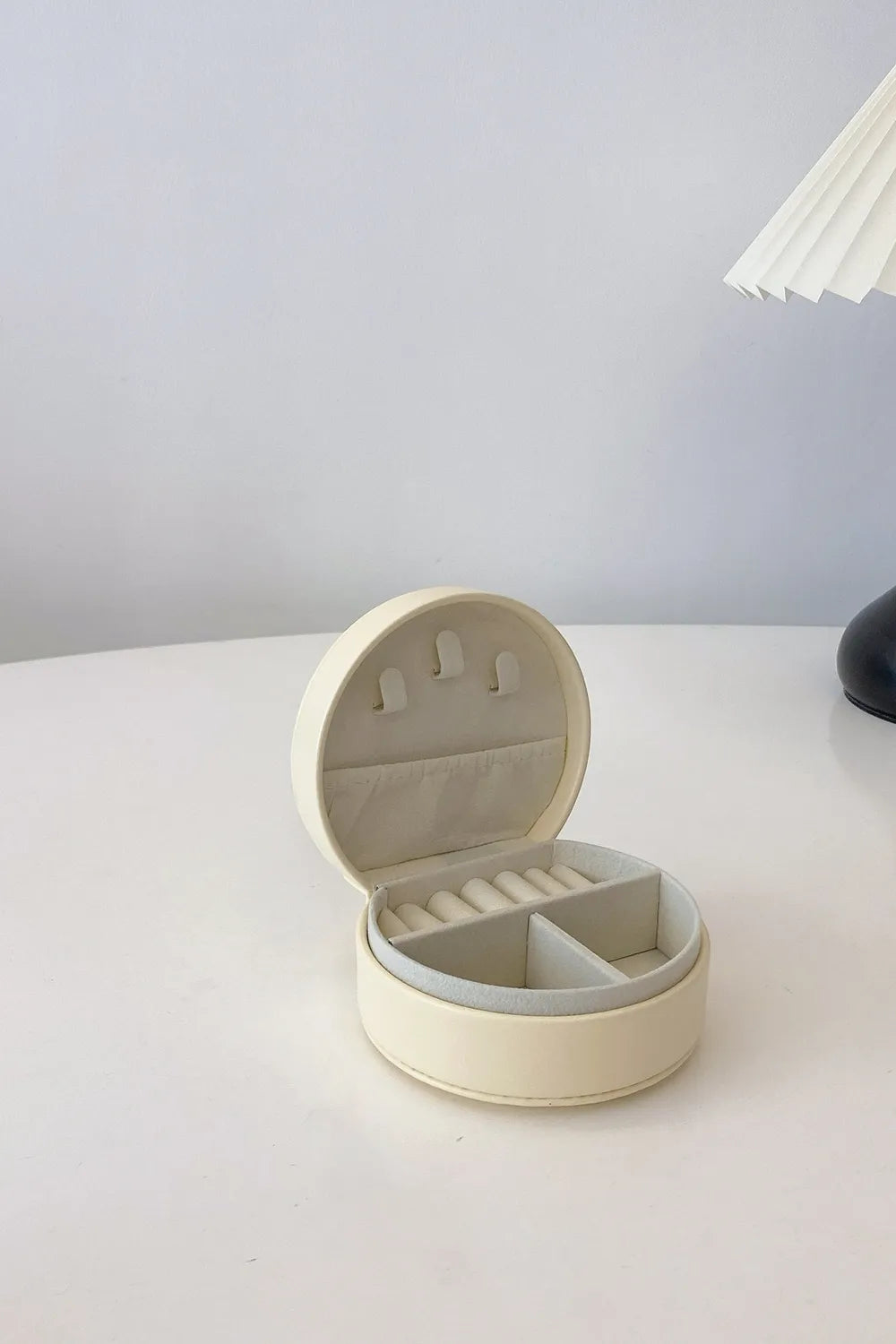 Cream round PU leather travel jewelry box with ring slots and interior divider