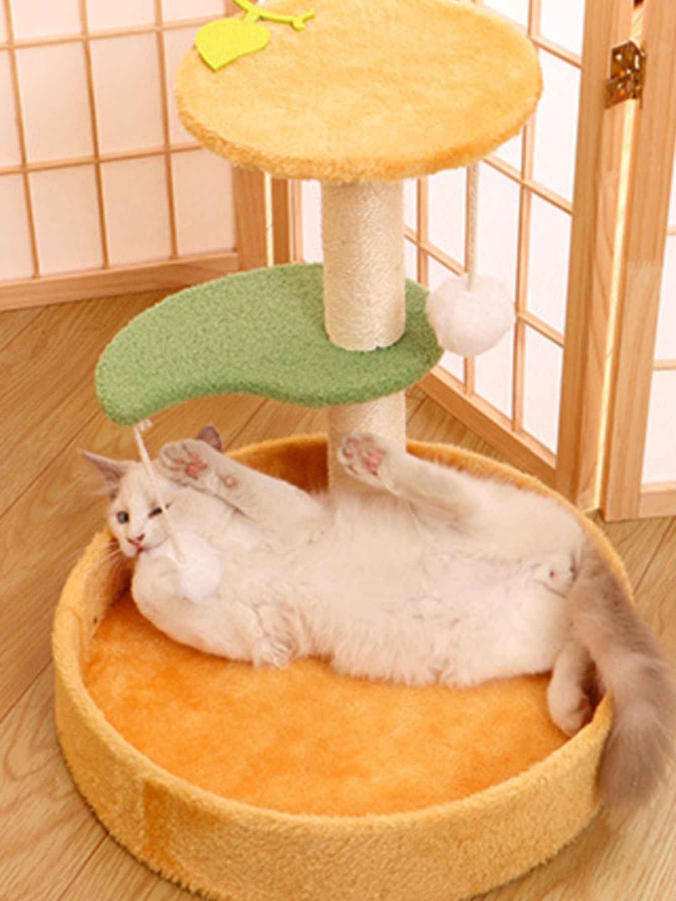 Round cat bed in orange fabric with green curved ramp and yellow cat-bed toy accents