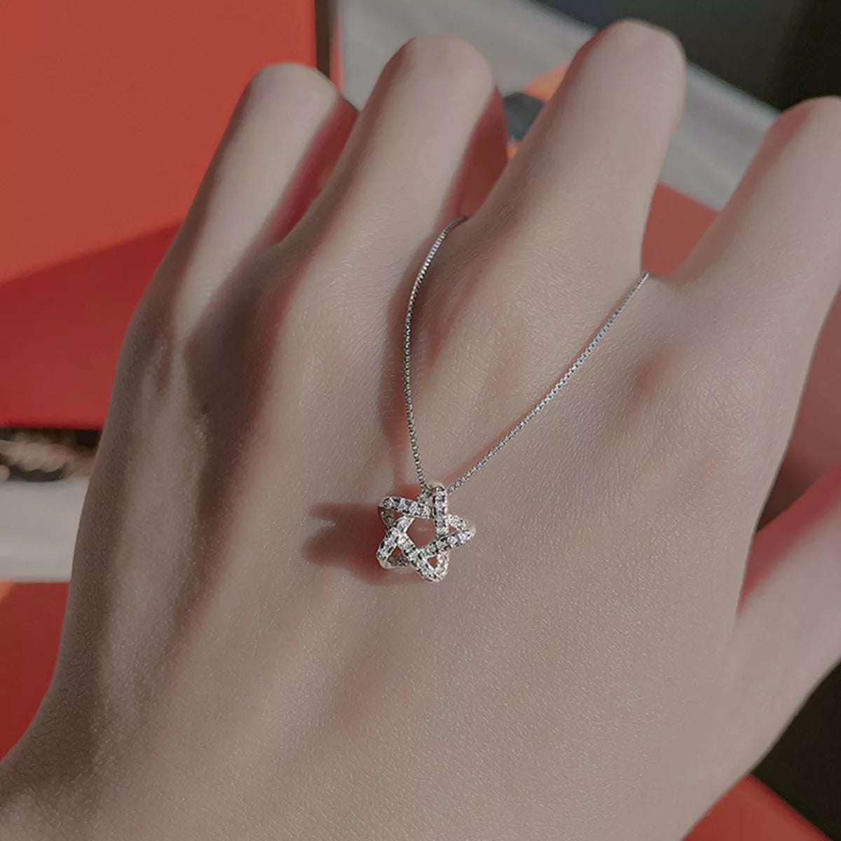 Silver zircon star pendant necklace worn on a thin chain