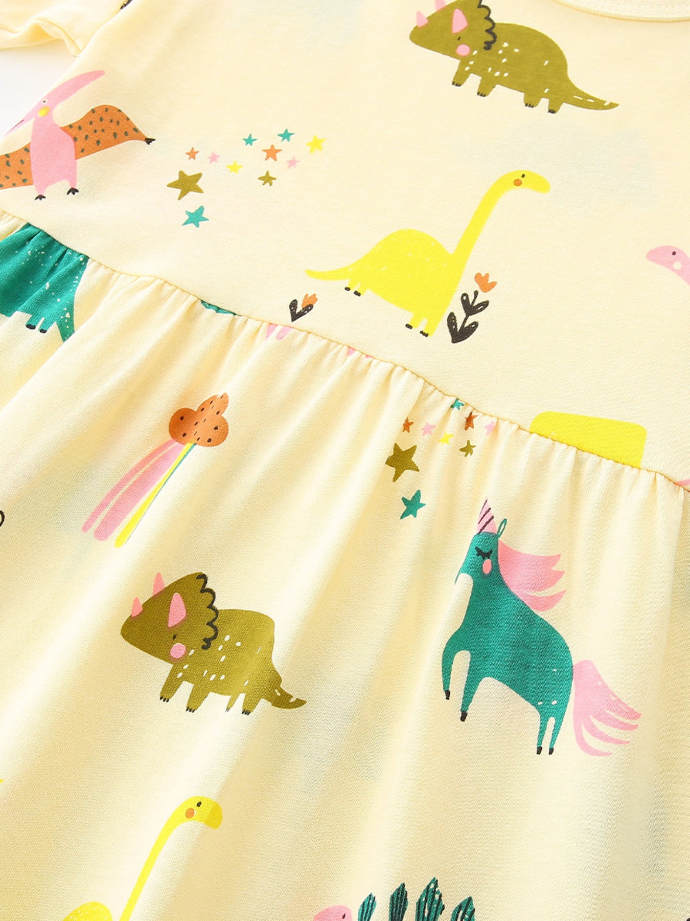 Pastel yellow dress bodice and skirt with colorful dinosaur graphics and elastic waist