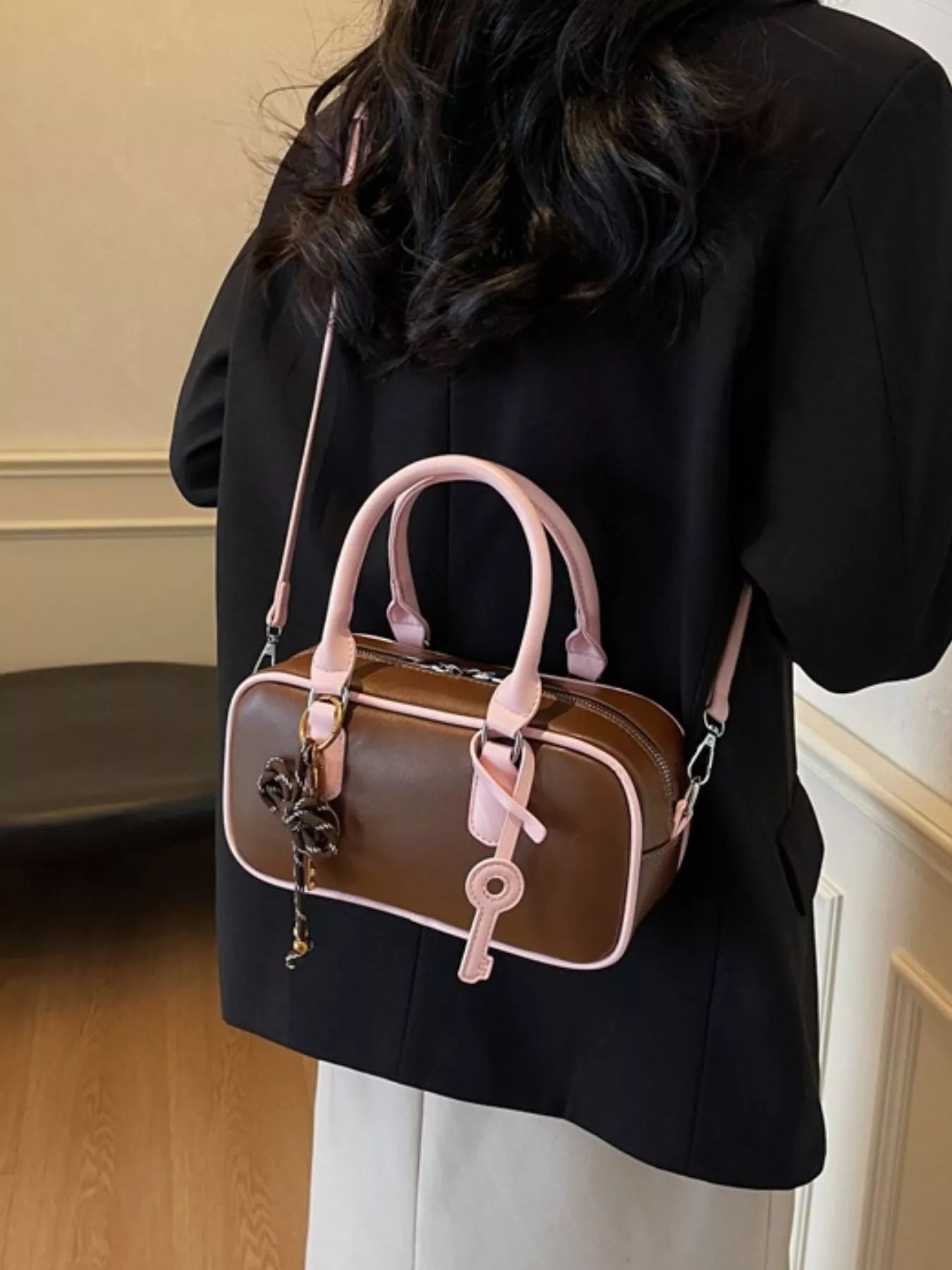 Braune Barrel Crossbody Bag, rosafarbene Tragegriffe und Schlüsselanhänger am Ring