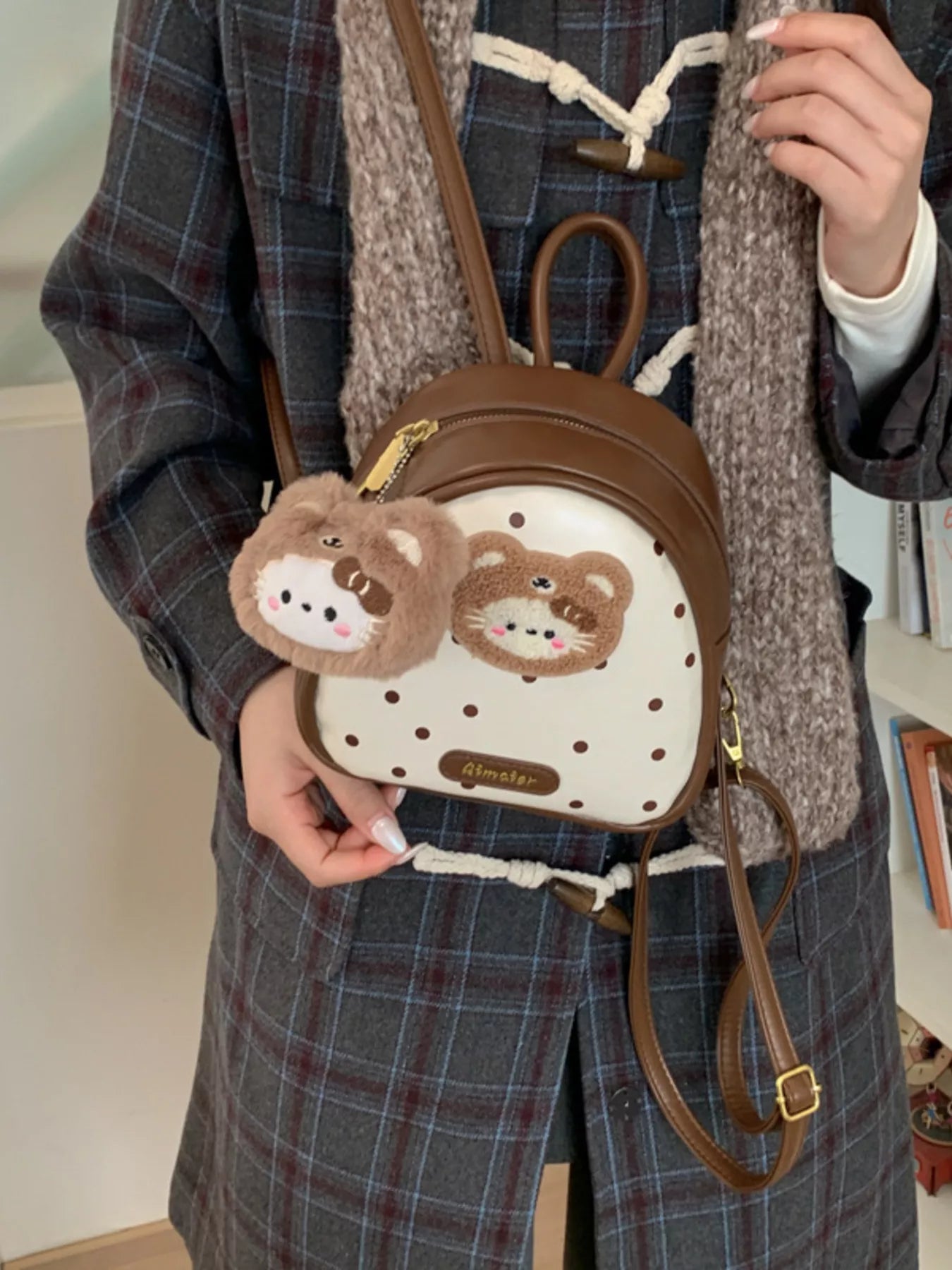Brown bear backpack bag with white dotted front and two plush animal charms
